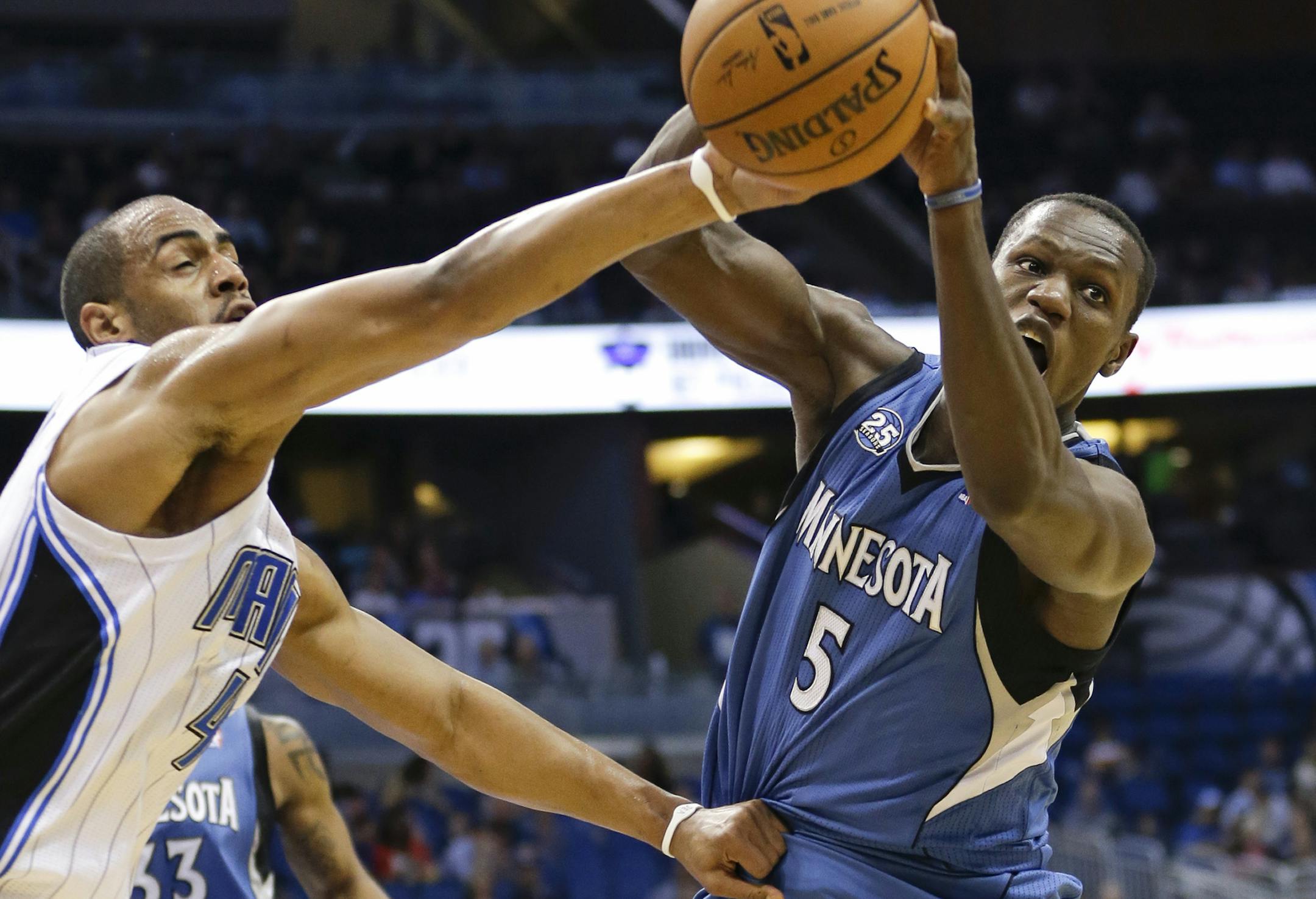 Orlando Magic's Arron Afflalo, left, and Minnesota Timberwolves' Gorgui Dieng (5) battle for a rebound during the first half of an NBA basketball game in Orlando, Fla., Saturday, April 5, 2014. (AP Photo/John Raoux)