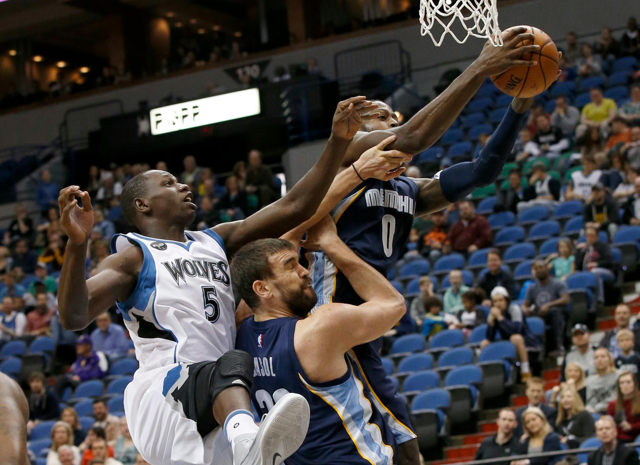Memphis Grizzlies forward JaMychal Green (0) pulls down a rebound over Minnesota Timberwolves center Gorgui Dieng (5) and Grizzlies center Marc Gasol, bottom,, during the first half of an NBA basketball game in Minneapolis, Sunday, Nov. 15, 2015. (AP Photo/Ann Heisenfelt)