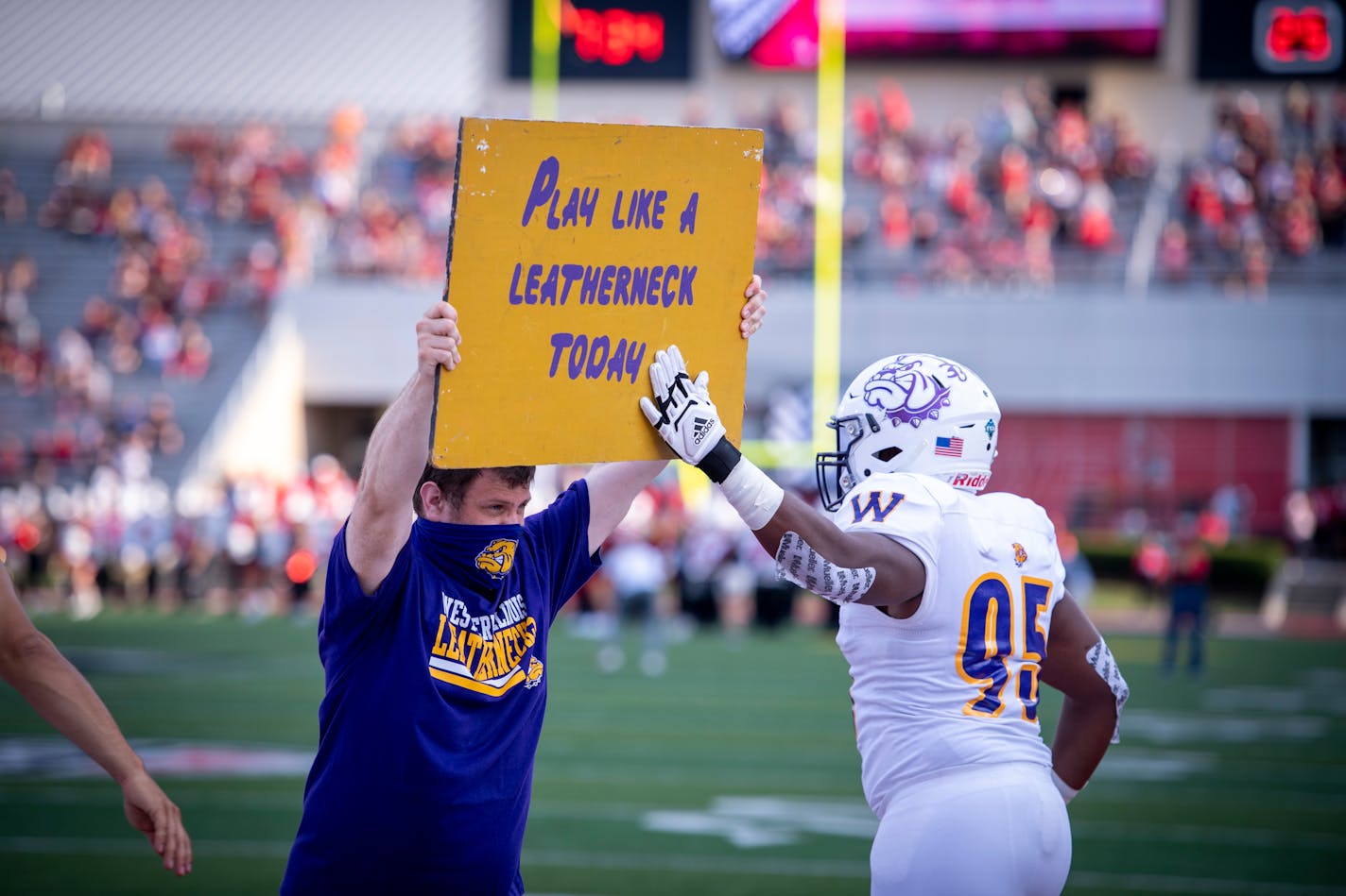 Members of Western Illinois run onto the field before an NCAA football game against Ball State, on Thursday, Sept. 2, 2021, in Muncie, Ind. (AP Photo/Doug McSchooler)