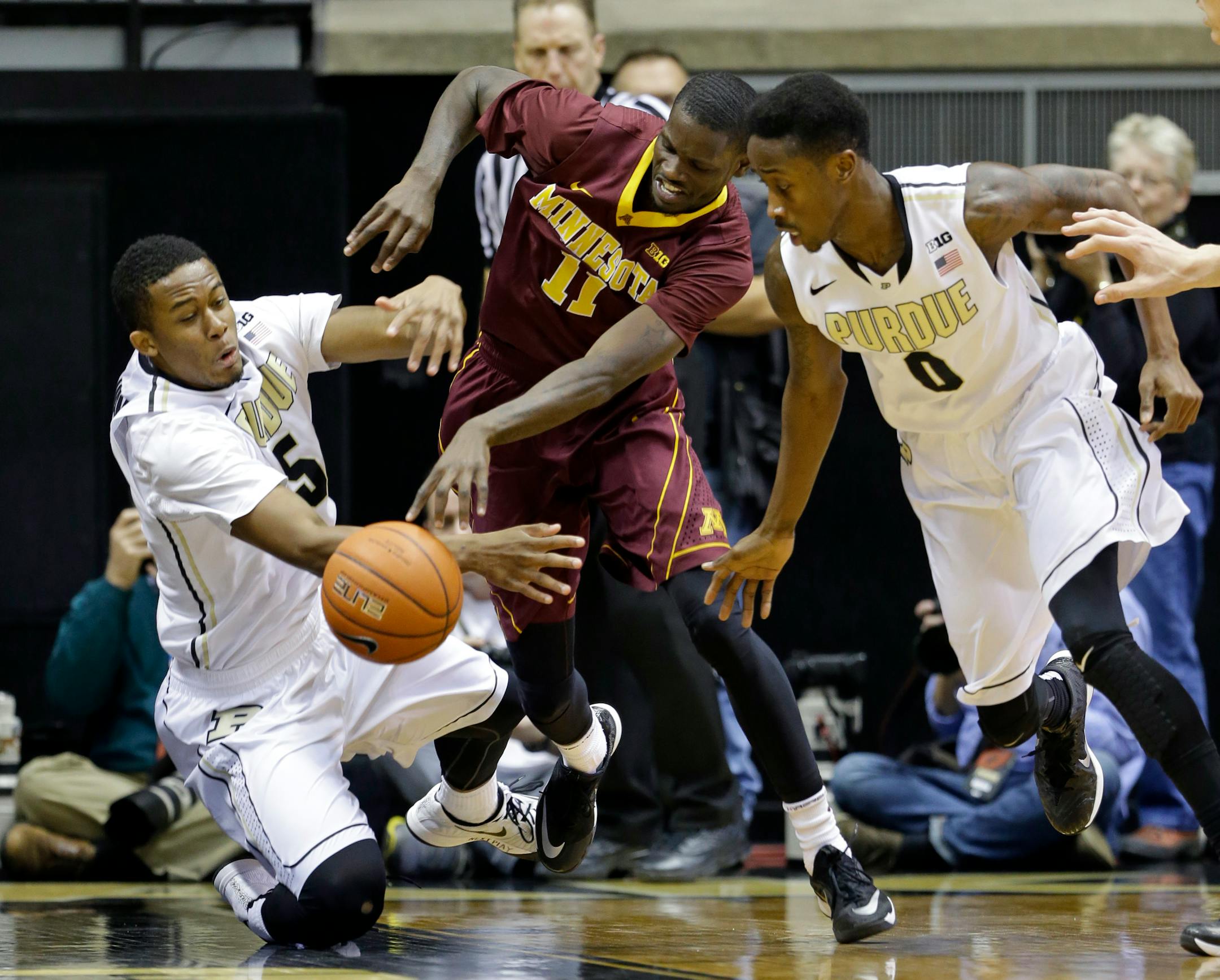 Gophers guard Carlos Morris (11) went for a loose ball between Purdue forward Basil Smotherman, left, and guard Jon Octeus (0) in the first half.