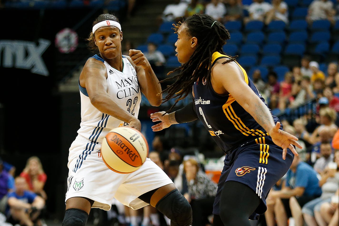 Minnesota Lynx forward Rebekkah Brunson (32) tries to pass the ball around Indiana Fever forward Erlanka Larkins during the first half of a WNBA basketball game, Friday, Sept. 4, 2015, in Minneapolis. (AP Photo/Stacy Bengs)