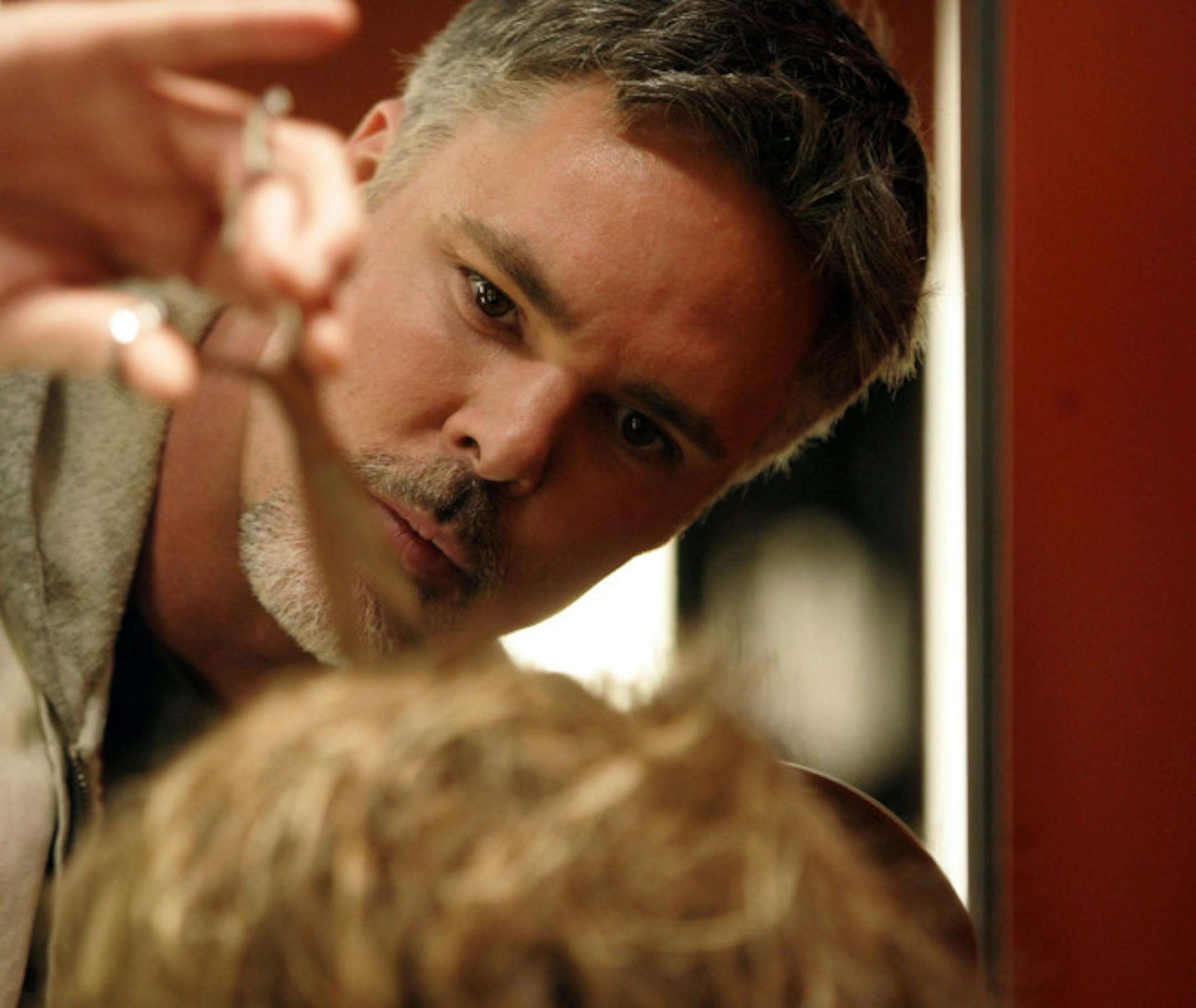 Christopher Hopkins, owner of reVamp, cut the hair of one of is makeover models Deb Amsler.