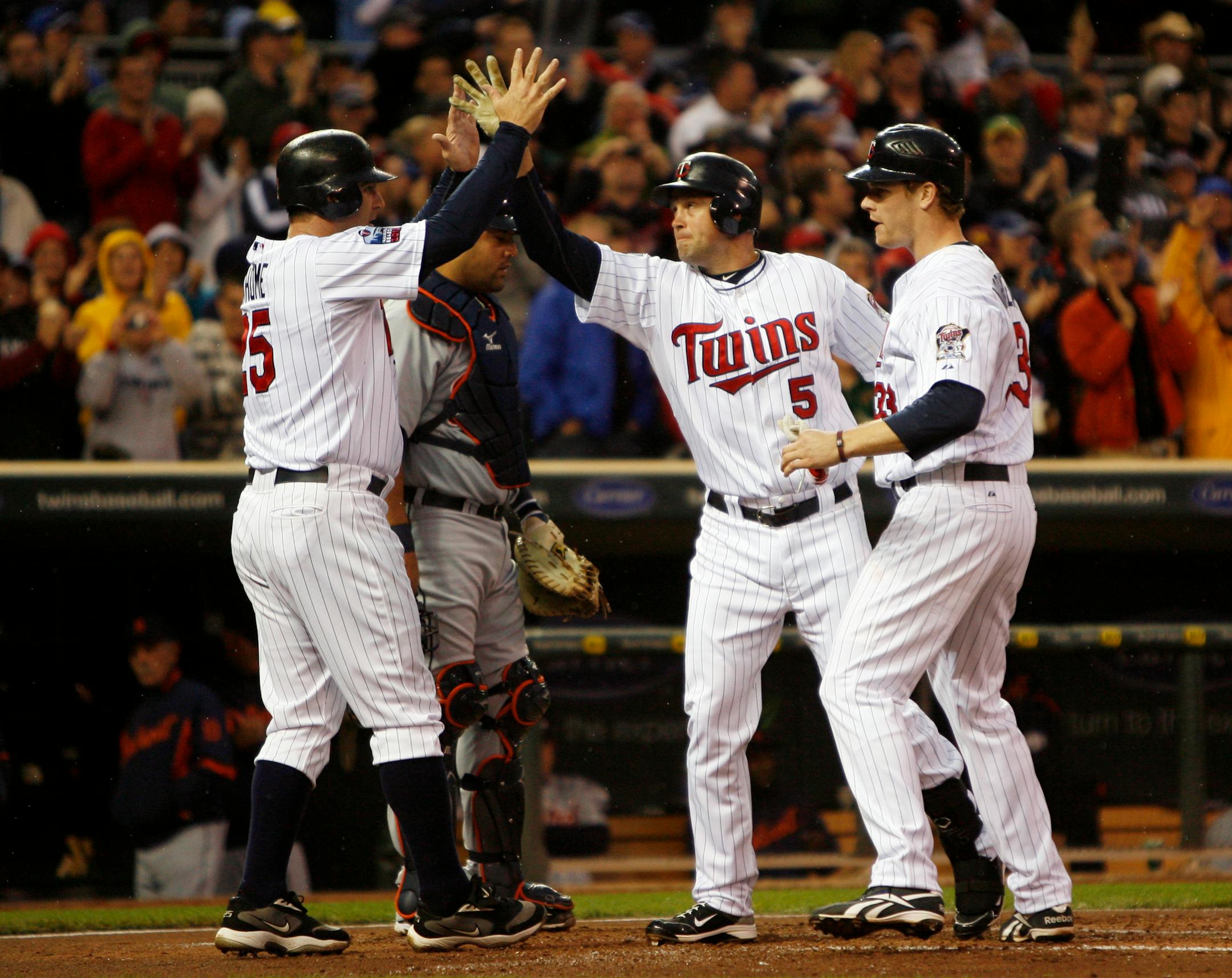 Michael Cuddyer (5) was welcomed at home plate by Jim Thome , left, and Justin Morneau after Cuddyer's three-run homer in the first inning against the Tigers in May.