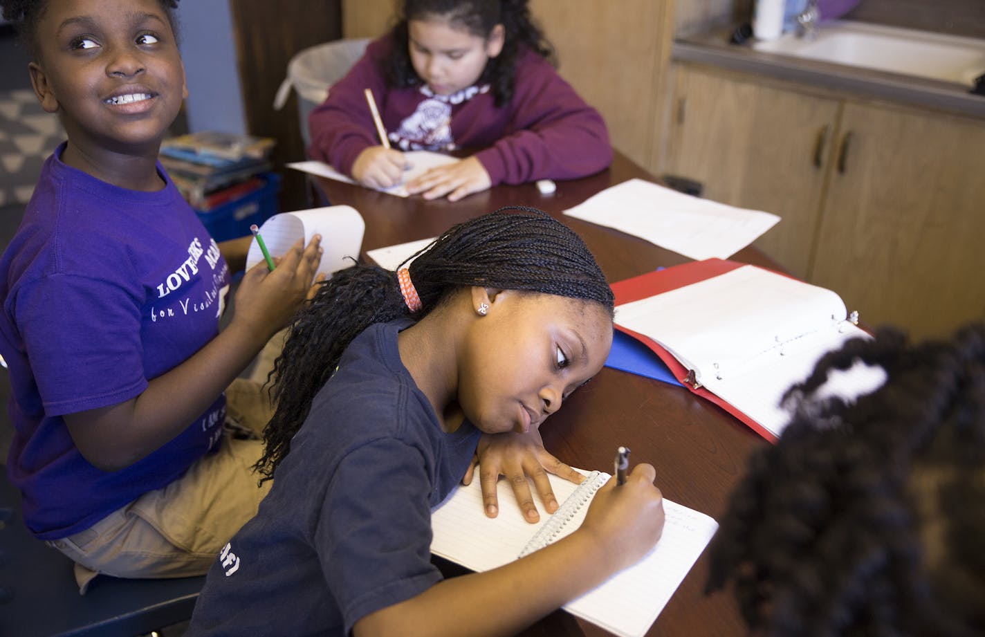 Third graders Trejiana Shelton, far left, and Carliyssia Thaddies, center, work on essays at Loveworks Academy charter school in Golden Valley on Monday, February 9, 2015. ] LEILA NAVIDI leila.navidi@startribune.com /