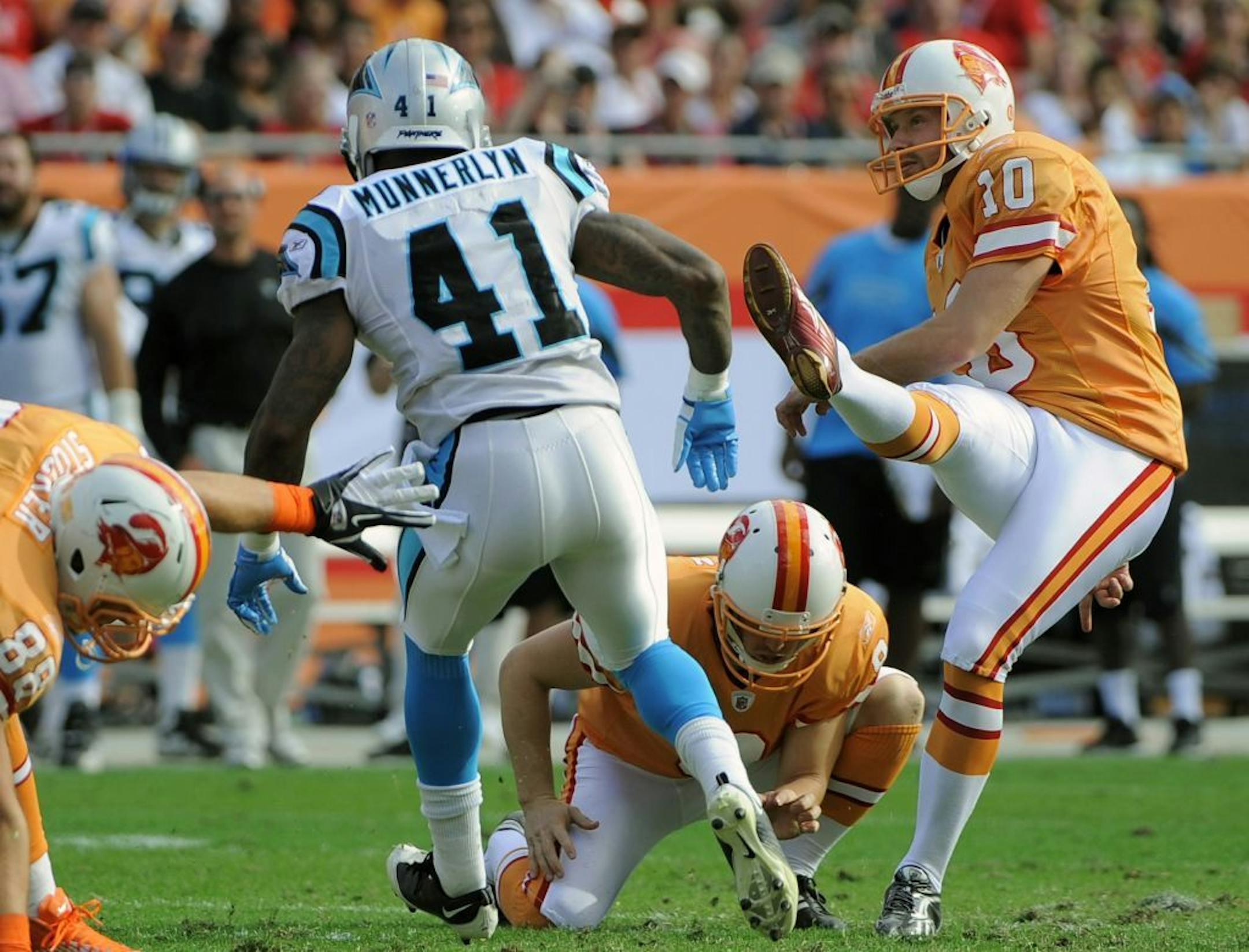 Tampa Bay Buccaneers kicker Connor Barth (10) follows through on a 44-yard field goal in front of Carolina Panthers cornerback Captain Munnerlyn (41) during the second quarter of an NFL football game on Sunday, Dec. 4, 2011, in Tampa, Fla. Tampa Bay' Michael Koenen holds for Barth.