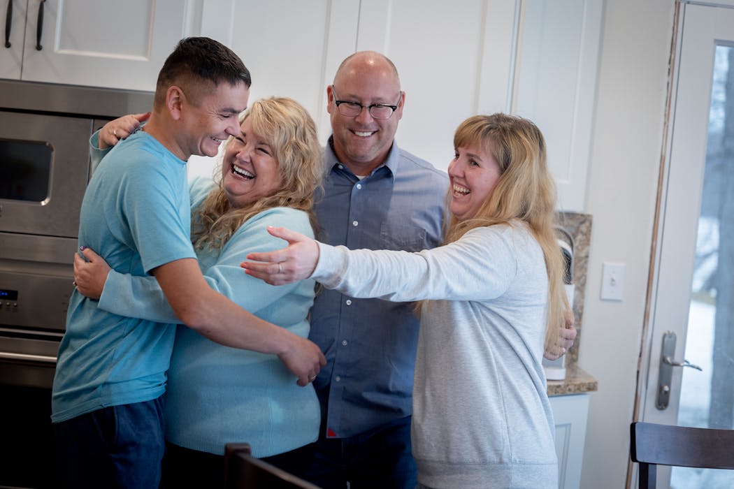 Gina and Bill Nelson, center, coaxed Vova Zlochevskyi and his wife Olesia Zlochevska, into a hug at their home in Pelican Rapids, Minn., on Sunday, March 20, 2022. Vova and Olesia are refugees from Ukraine. The family fled Chernihiv and flew to Tijuana in an attempt to seek asylum and are now living in Pelican Rapids with the Nelson family. 