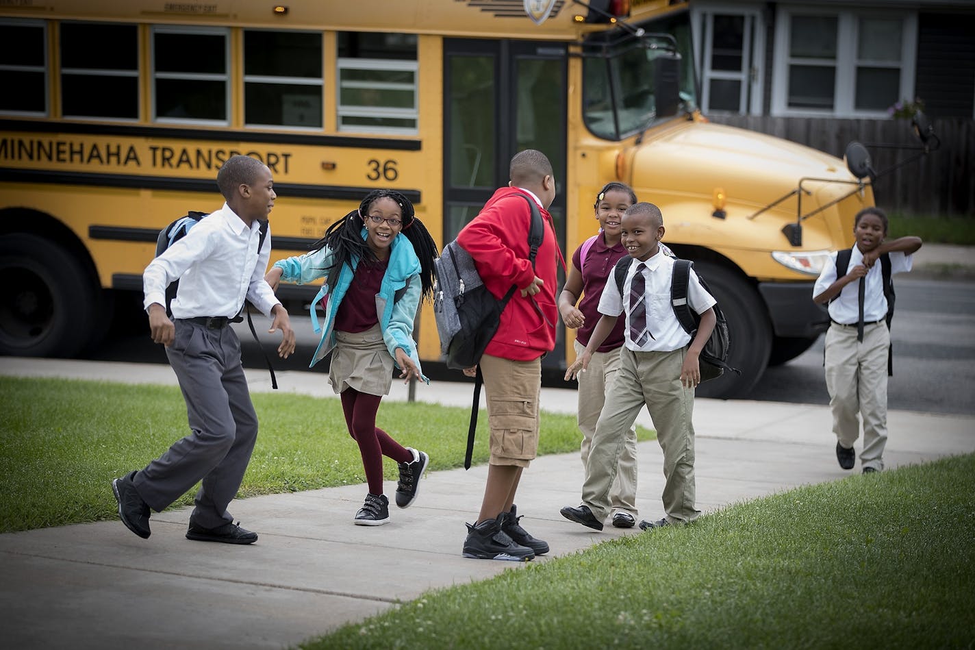 Mastery School students make their way off the school bus in August at a Minneapolis charter school that's part of the Harvest Network.