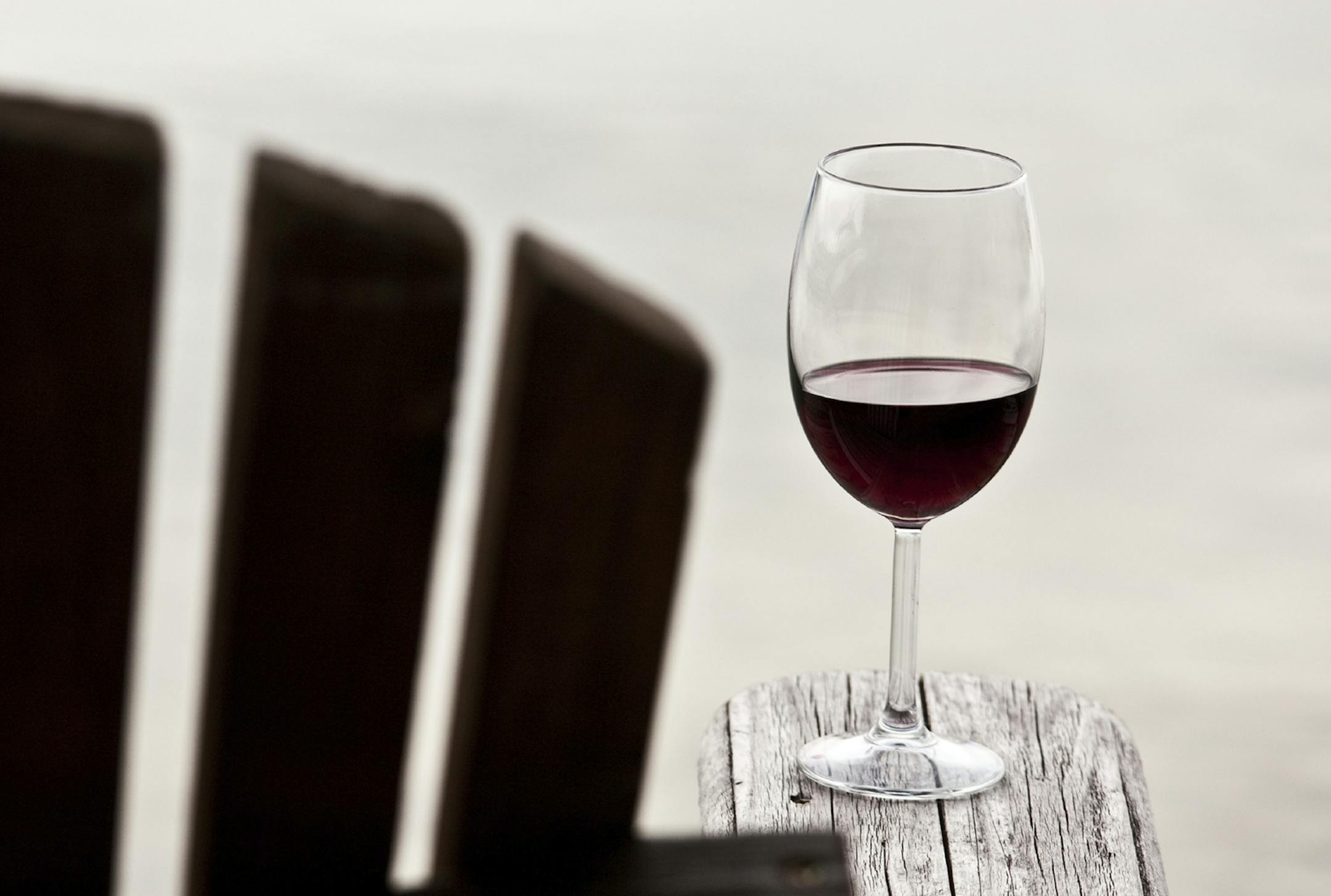 Glass of red wine on an adirondack chair. Istockphoto.com