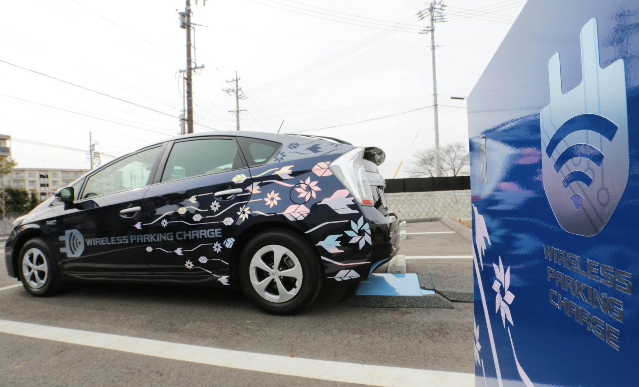 A Toyota Motor Corp. Prius PHV plug-in hybrid vehicle reverses to park over the company's wireless vehicle charging system, which uses magnetic-resonance technology, during a demonstration in Toyota City, Aichi Prefecture, Japan, on Thursday, Feb. 13, 2014. The company has set a target of selling an unprecedented 10.32 million vehicles in 2014 after leading General Motors Co. and Volkswagen AG in global deliveries for a second straight year in 2013. Photographer: Yuriko Nakao/Bloomberg ORG XMIT: