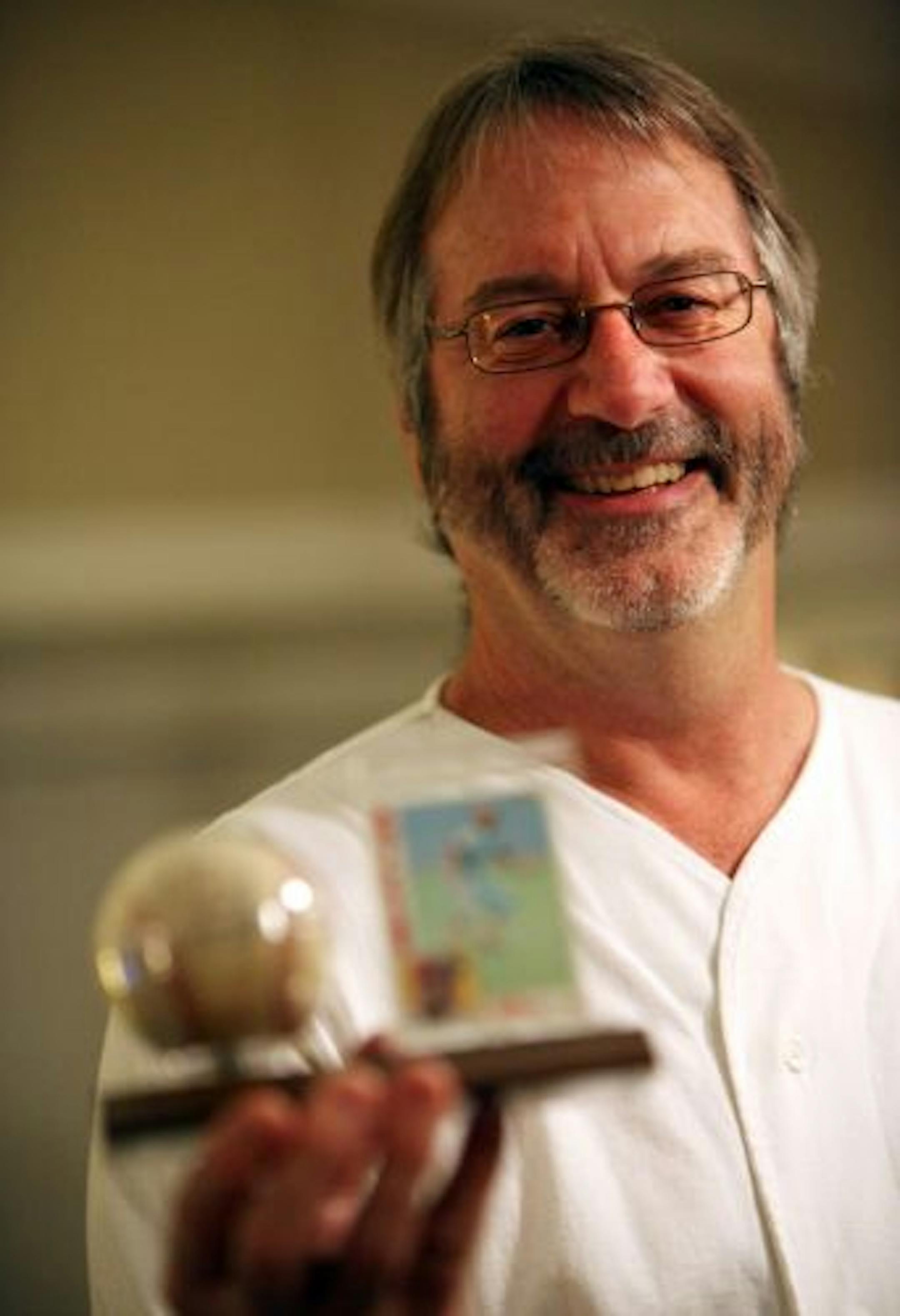 Dave Crane holds the foul ball he caught in 1982 at the first exhibition game at the Metrodome. He also has the card of the Phillies' ball player, Ivan DeJesus, who hit the ball.