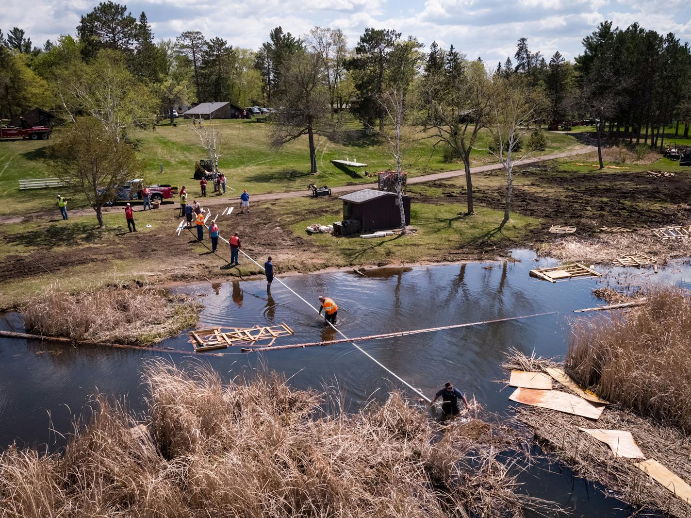 Workers attempted to place a cable above and below the bog on North Long Lake last week with the intent to split the bog in two to make it more manageable to remove.