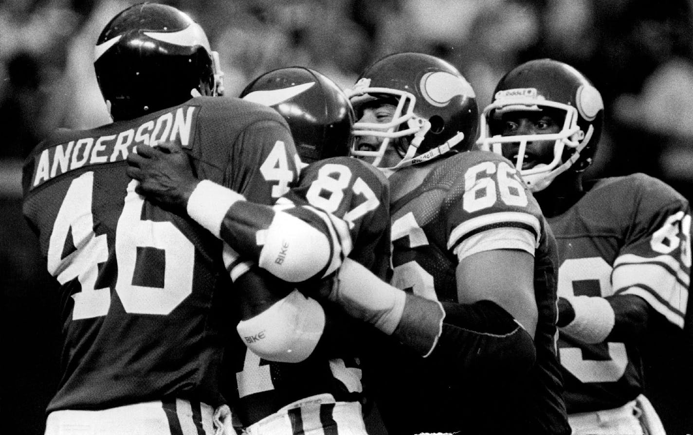 Running back Alfred Anderson was congratulated by Vikings teammates Leo Lewis (87), Terry Tausch (66) and Mike Jones (89) after Anderson threw a touchdown pass to Dwight Collins in a victory over Atlanta in 1984.