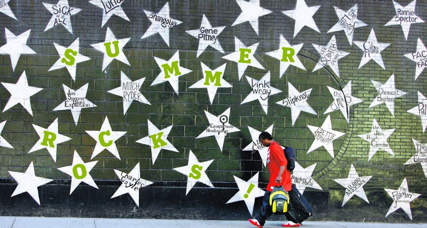 A pedestrian makes his way along Hennepin Ave., past First Avenue, where stars with the names of musicians who have played the famous venue are painted on the wall.