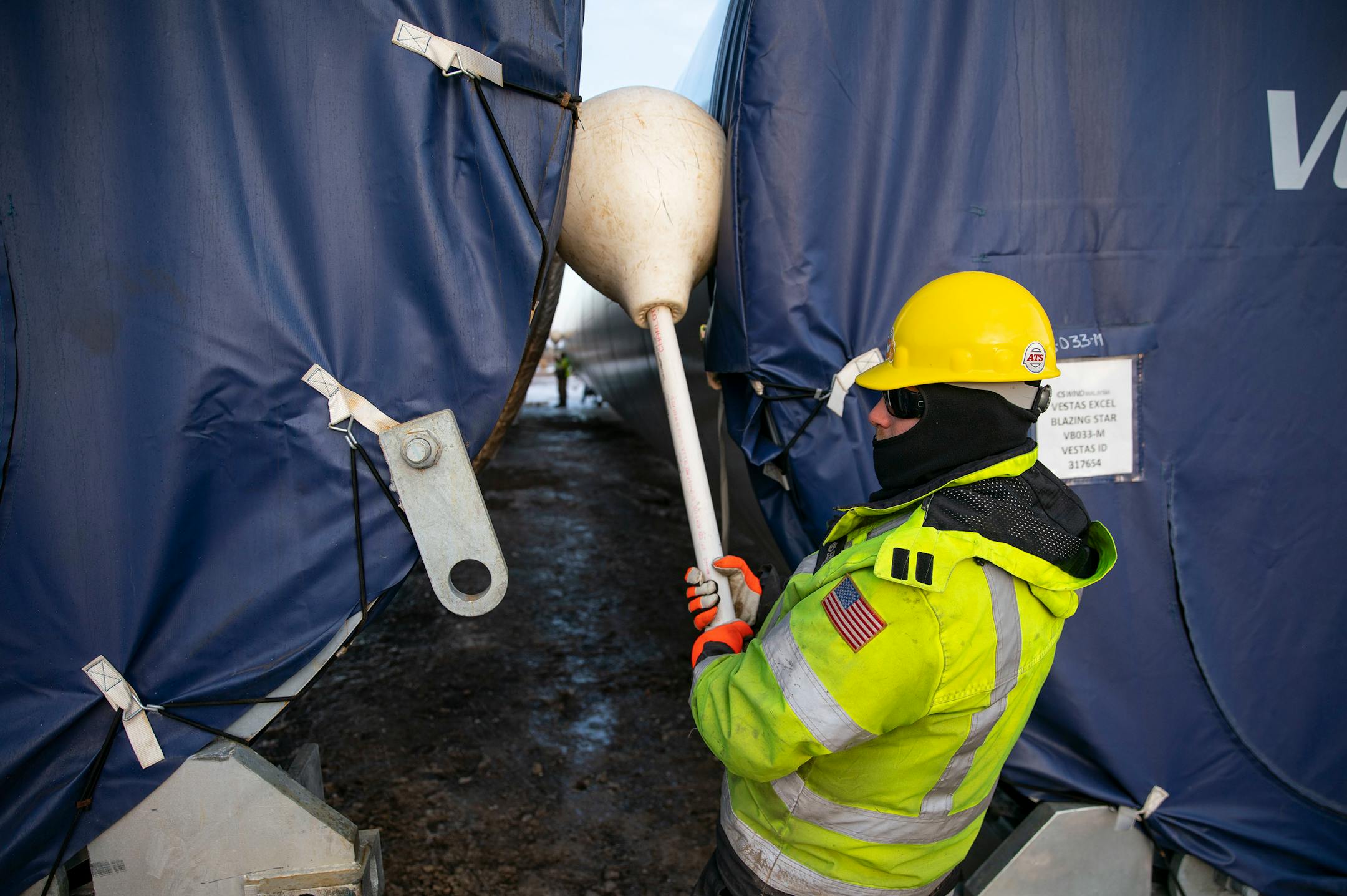 A worker held a plastic "lollipop" to ensure the wind turbine tower sections are not placed too close together.