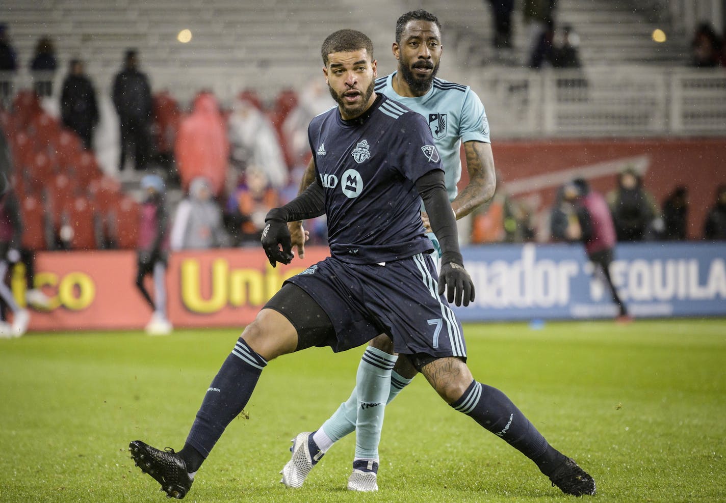 Toronto FC forward Jordan Hamilton (7) and Minnesota United defender Romain Metanire (19) battle for position in second-half MLS soccer match action in Toronto, Friday, April 19, 2019. (Christopher Katsarov/The Canadian Press via AP)