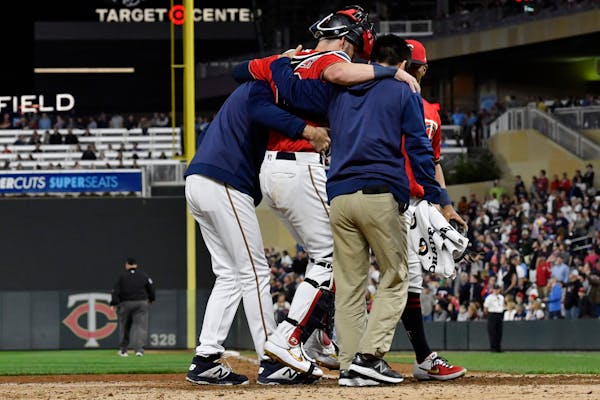 Twins catcher Mitch Garver was helped off the field after he was injured tagging out the Angels' Shohei Ohtani in the eighth inning Tuesday night. Gar