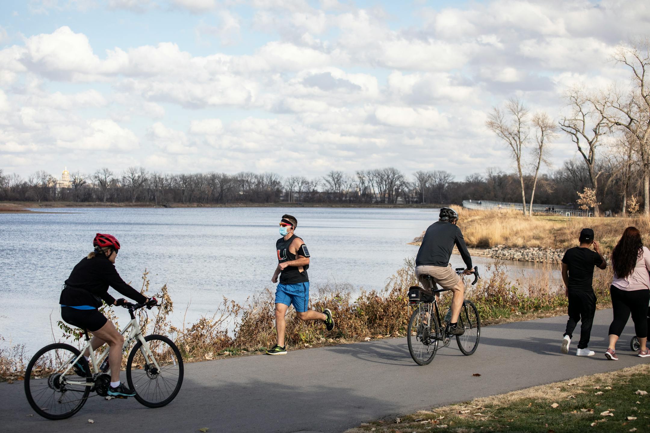 FILE — A jopgger wears a face mask while running around Gray's Lake in Des Moines on Nov. 8, 2020.