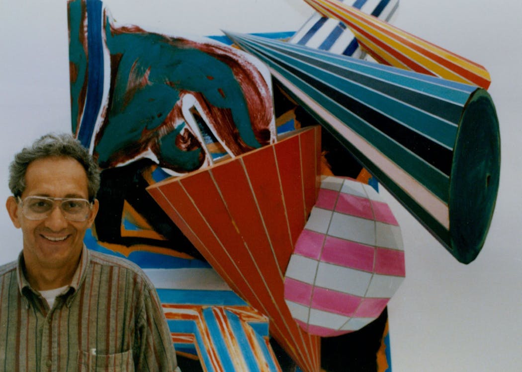In 1988, artist Frank Stella stands in front of dimensional paintings that were being installed at the Walker Art Center as a part of a major retrospective of Stella's work.  