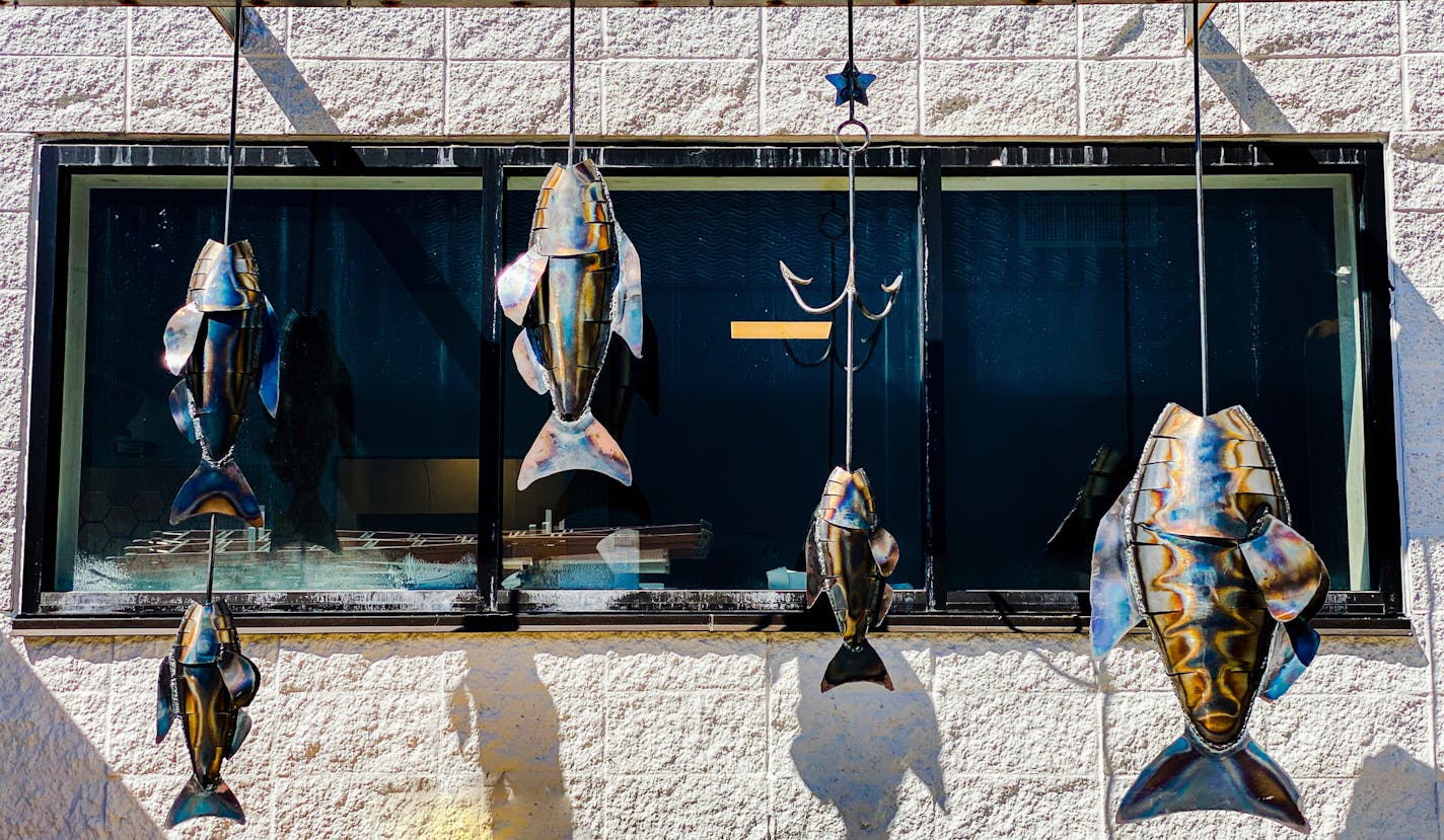 Metal fish hang outside Coastal Seafoods' new Minneapolis home.