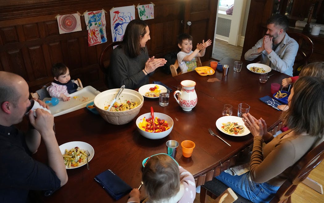 Axel Schulke, 3, gets a round of applause from the table after sharing what he’s most thankful for on Friday, the last night living together in a home his parents co-purchased with friends in 2017.