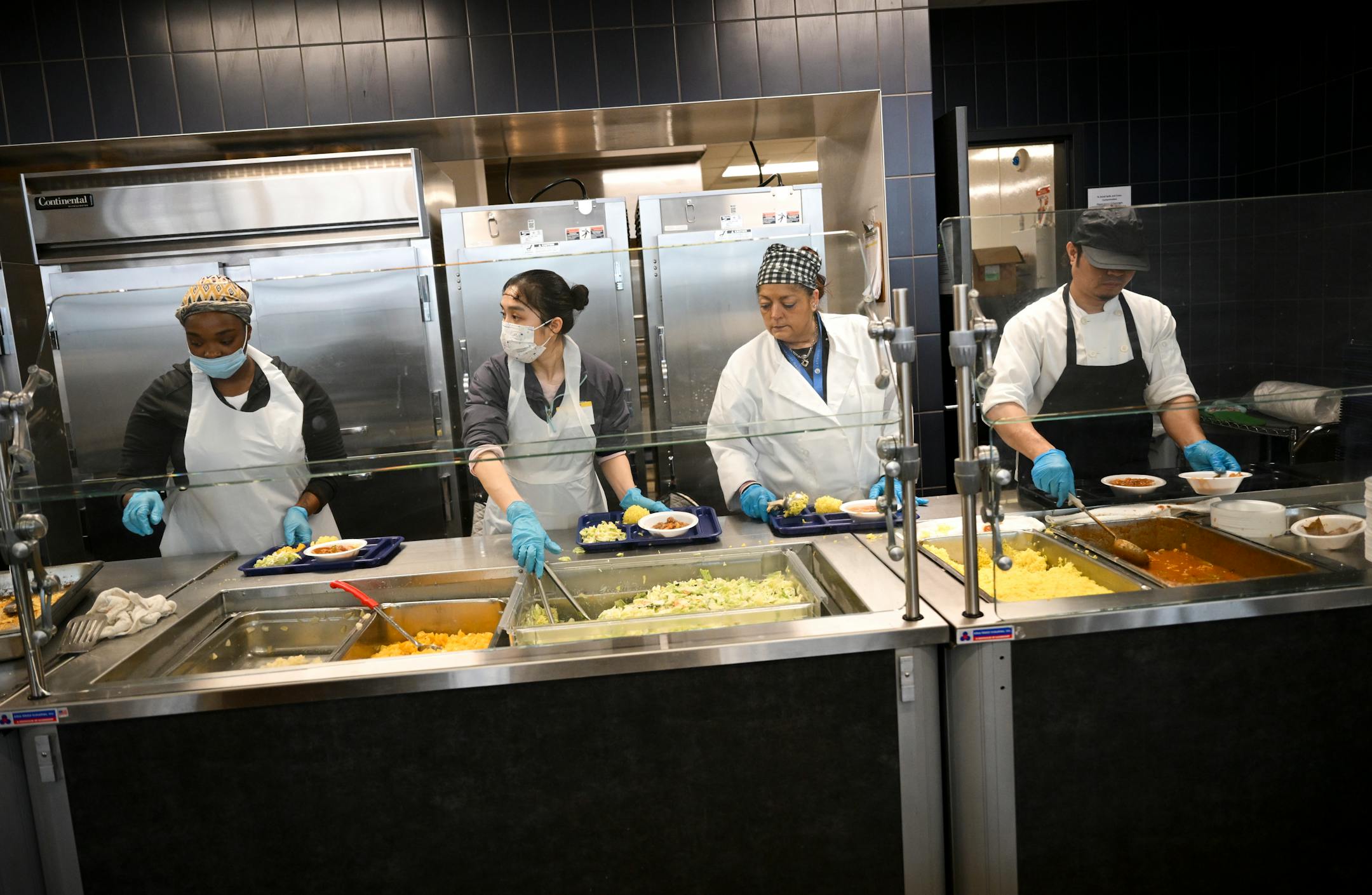 Employees and volunteers dish up lunch for people seeking shelter from the cold Friday at the Dorothy Day Opportunity Center in St. Paul. Twin Cities nonprofits are opening their doors to provide shelter to those who need a place to keep warm as the first cold snap of the season arrives this weekend.