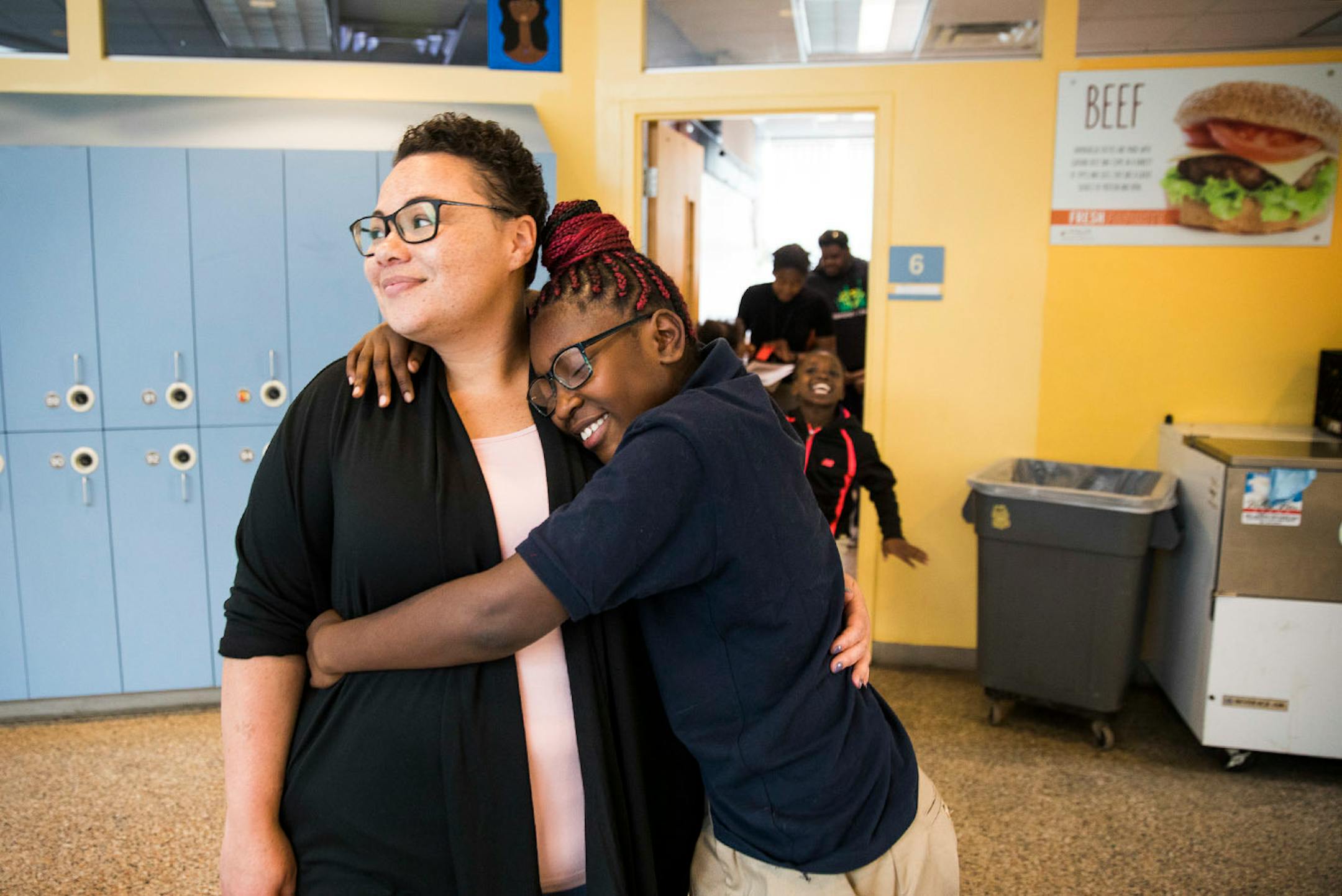 Catrice O'Neal, the director of Out of School Time programs, gets a spontaneous hug from Ebonie Kennedy, 10.