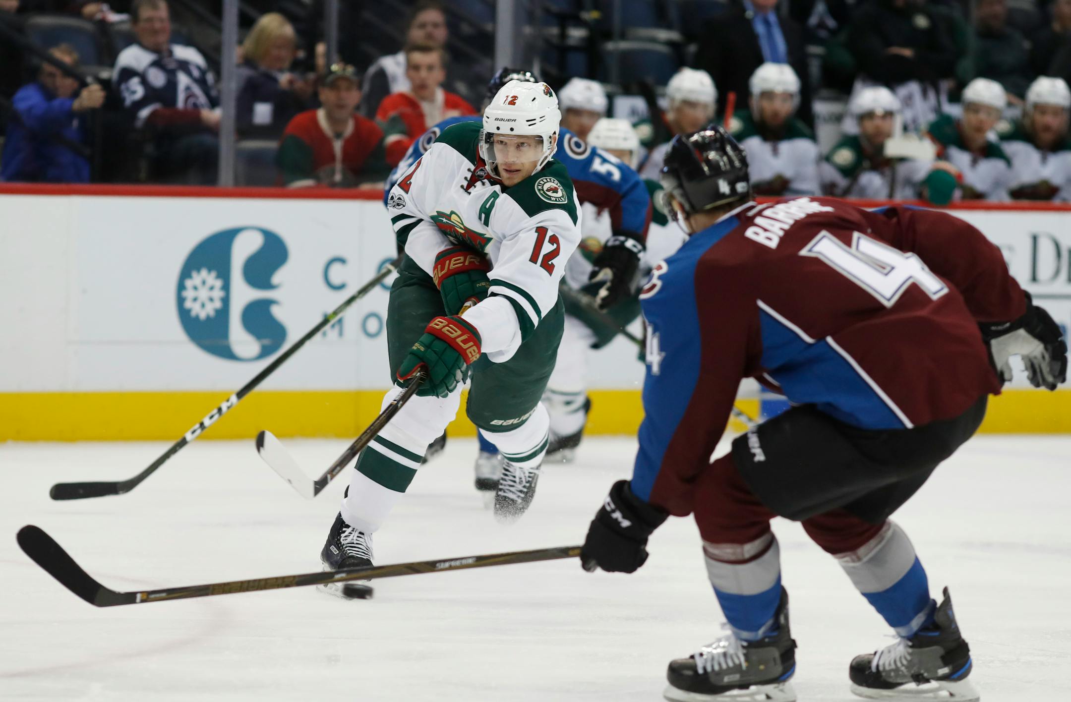 Minnesota Wild center Eric Staal, center, takes a shot as he skates between Colorado Avalanche defensemen Tyson Barrie, front, and Anton Lindholm, of Sweden, in the second period of an NHL hockey game Thursday, April 6, 2017, in Denver. (AP Photo/David Zalubowski)