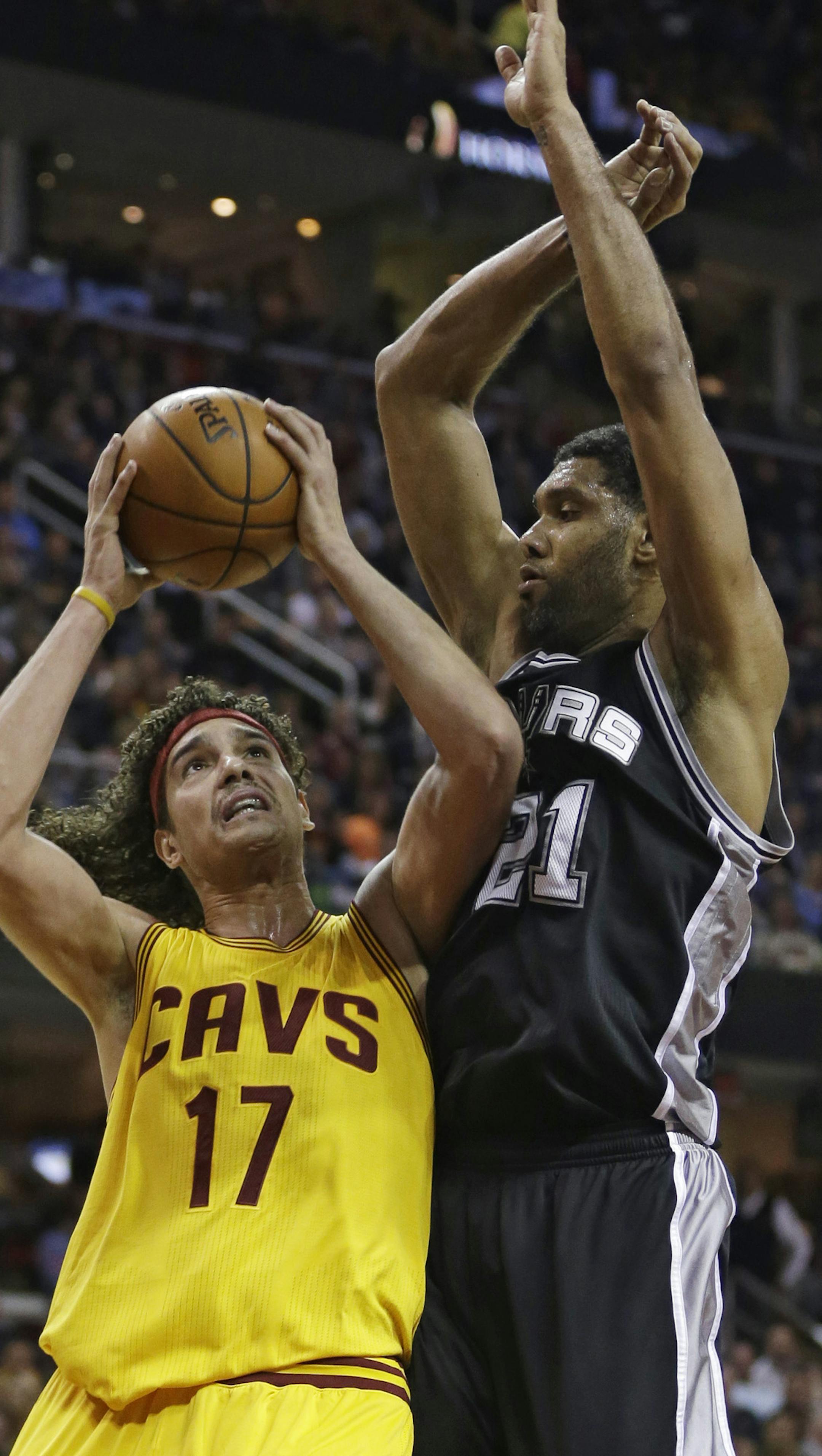 San Antonio Spurs' Tim Duncan (21) defends against Cleveland Cavaliers' Anderson Varejao (17), from Brazil, during an NBA basketball game Wednesday, Nov. 19, 2014, in Cleveland. (AP Photo/Tony Dejak) ORG XMIT: OHTD10