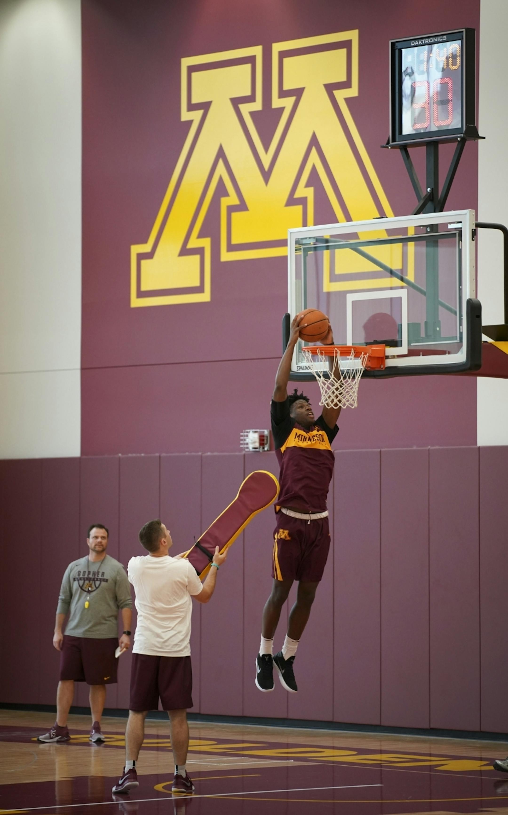 Center Daniel Oturu, still recovering from an injury, dunked during a drill at practice.
