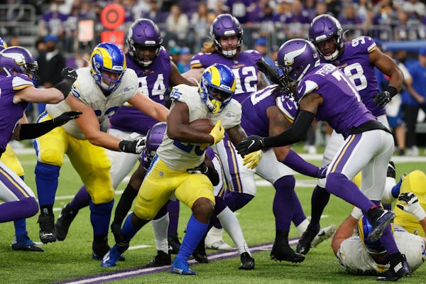 Los Angeles Rams running back Sony Michel (25) runs from Minnesota Vikings defenders during the first half of an NFL football game, Sunday, Dec. 26, 2