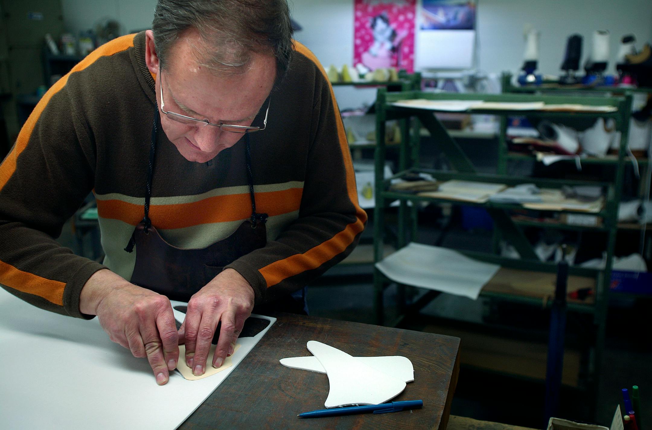 Riedell Skate Company's custom boot maker Lee Olson cut out pieces that will be used in a pair of ice skates to stiffen the boot and provide greater support for the skater.