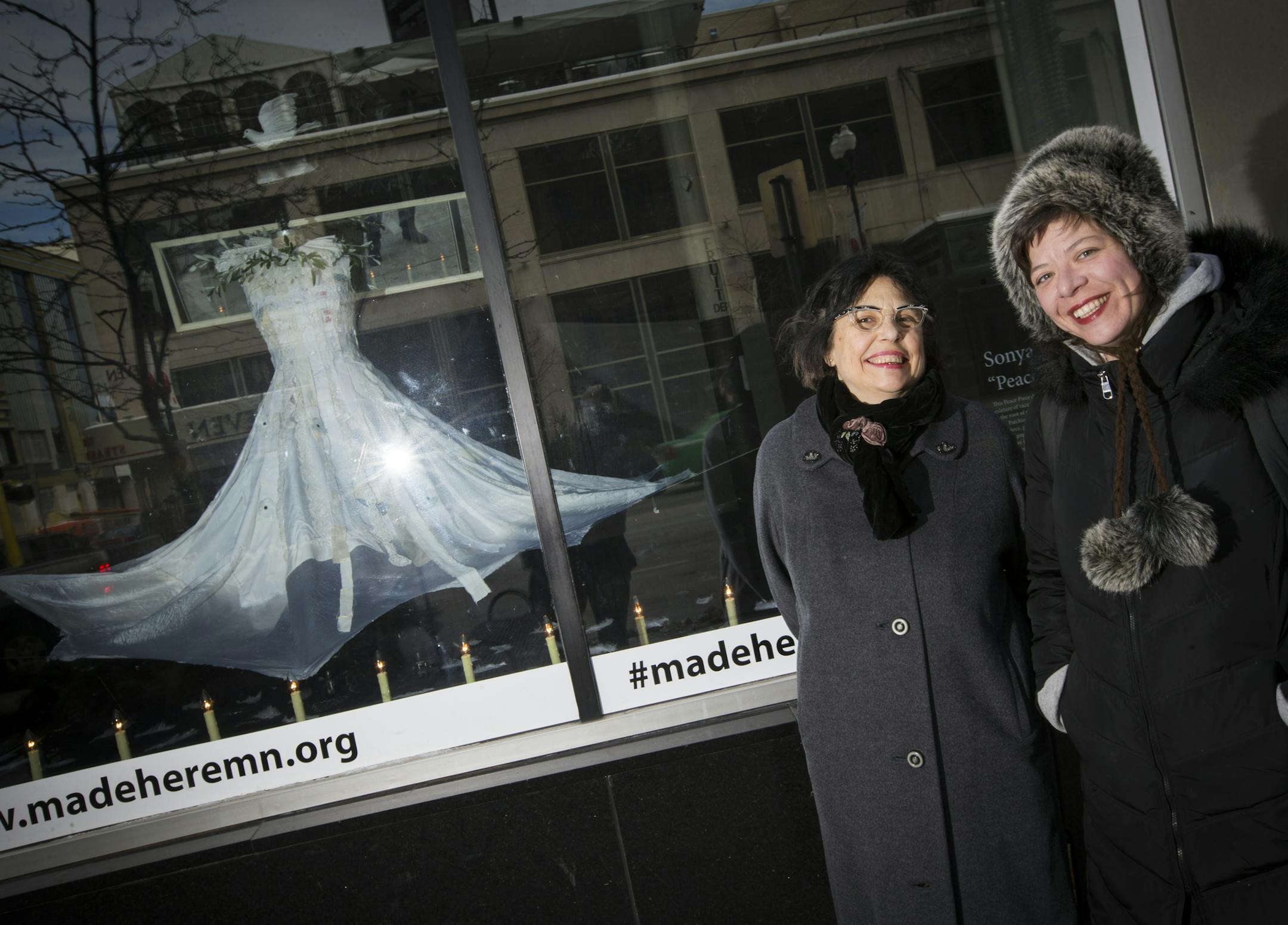 Joan Vorderbruggen, right, organized 61 Twin Cities artists to create 38 storefront window displays that will fill the downtown "Cultural District" with "Brilliance!" (their theme) during the holiday season. She posed for a photograph with artist Sonya Berlovitz in front of Berlovitz's installation Peace Piece on the corner of Hennepin Ave and 7th St. in Minneapolis, Minn., on Friday, November 21, 2014. ] RENEE JONES SCHNEIDER • reneejones@startribune.com