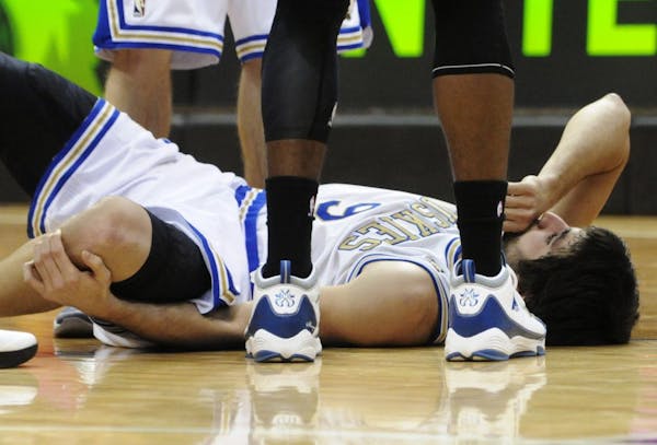 Wolves point guard Ricky Rubio held his left knee after he tore his ACL against the Lakers on Friday.