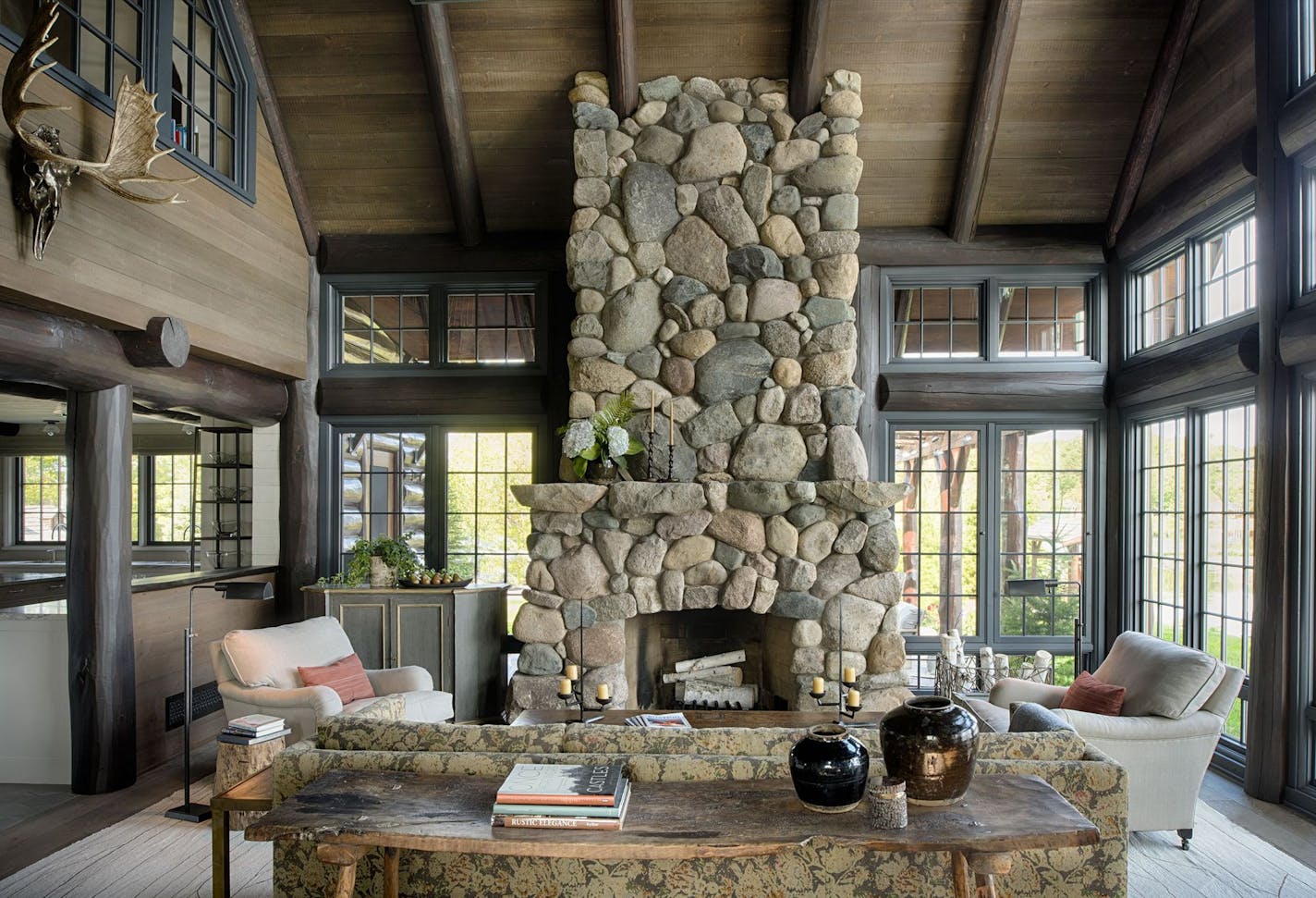 Stone, wood and exposed-log construction add warm character to this northern Minnesota cabin by Rehkamp Larson Architects.