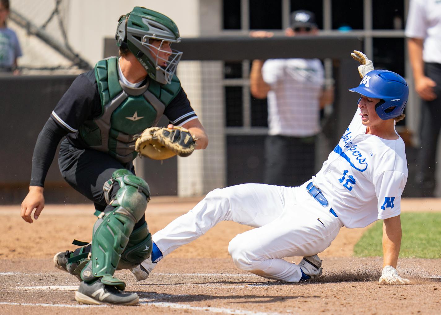 Minnetonka second baseman Colten Benedict (12) slides into home plate on an RBI double in front of Mounds View catcher Drew Rogers (32) to win a 4A quarterfinals game 4-3 in the seventh inning Tuesday, June 13, 2023, at CHS Field in St. Paul, Minn. ]