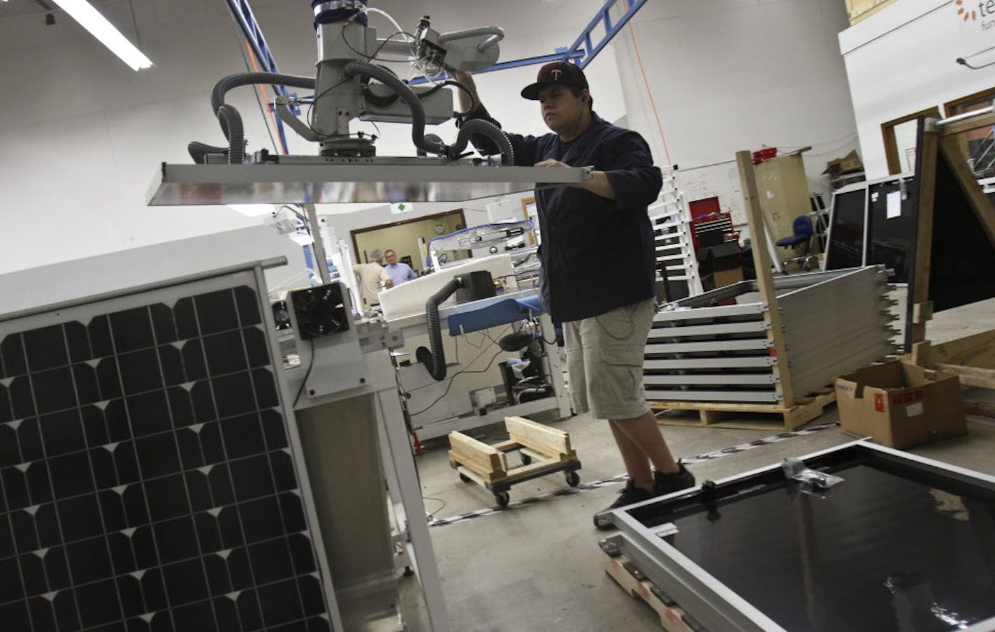 Colton Goodhart employee of tenkSolar guided a panel into place for a final power test to make sure that it meets certain specifications in Bloomington, Minn., Wednesday, September 7, 2011. ] (KYNDELL HARKNESS/STAR TRIBUNE) kyndell.harkness@startribune.com