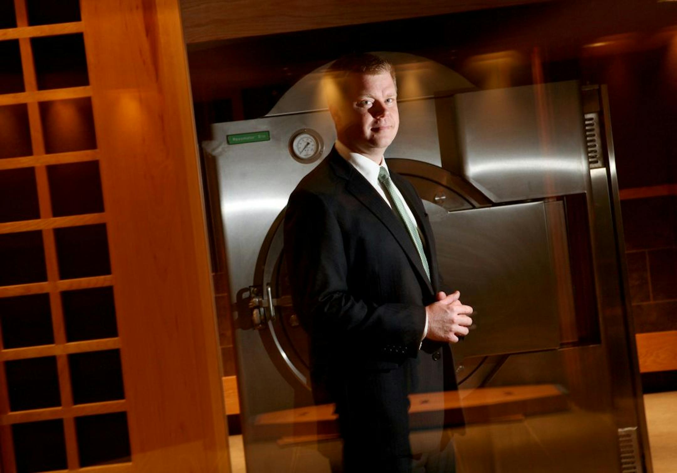 Jason Bradshaw, vice-president and COO of Bradshaw Funeral and Cremation Services, stands by the Resomator, a "green cremation" machine, prior to its first use in the Green Cremation Chapel at the Celebration of Life Center in Stillwater July 11, 2012. Instead of fire-based cremation, the machine uses a water process. Bradshaw is seen behind a glass wall. This is the view that loved ones would have if they chose to spend time with the deceased prior to a green cremation.