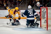 Gophers left winger Mason Nevers was upended by Penn State center Jimmy Dowd Jr. but still scored against Nittany Lions goalie Liam Souliere during Mi
