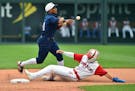 Second baseman Jorge Polanco (11) of the Minnesota Twins gets the force out on Whit Merrifield (15) of the Kansas City Royals as he throws to first in