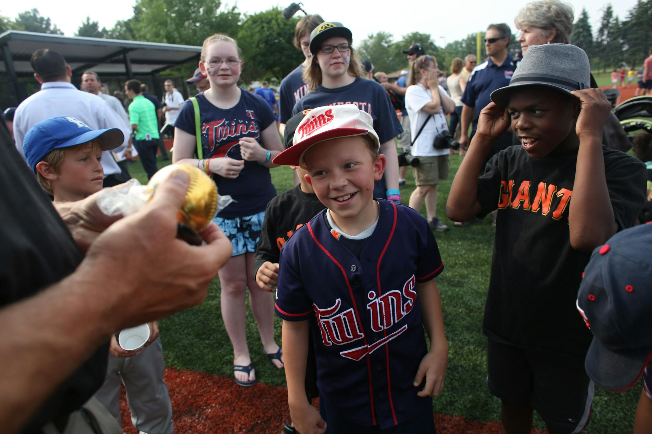 Roy Broberg, 10, smile as he got his golden baseball signed by former Twin Corey Koskie after the dedication ceremony. ] (KYNDELL HARKNESS/STAR TRIBUNE) kyndell.harkness@startribune.com At Lee Field in St. Paul, Min. Thursday, July 9, 2014. A baseball field in Robbinsdale has gotten a big upgrade, with a large part of the funding coming from Major League Baseball in conjunction with the All Star game.