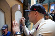 Joe Mauer signs the spot on Thursday where his plaque will be added at the National Baseball Hall of Fame in Cooperstown, N.Y.