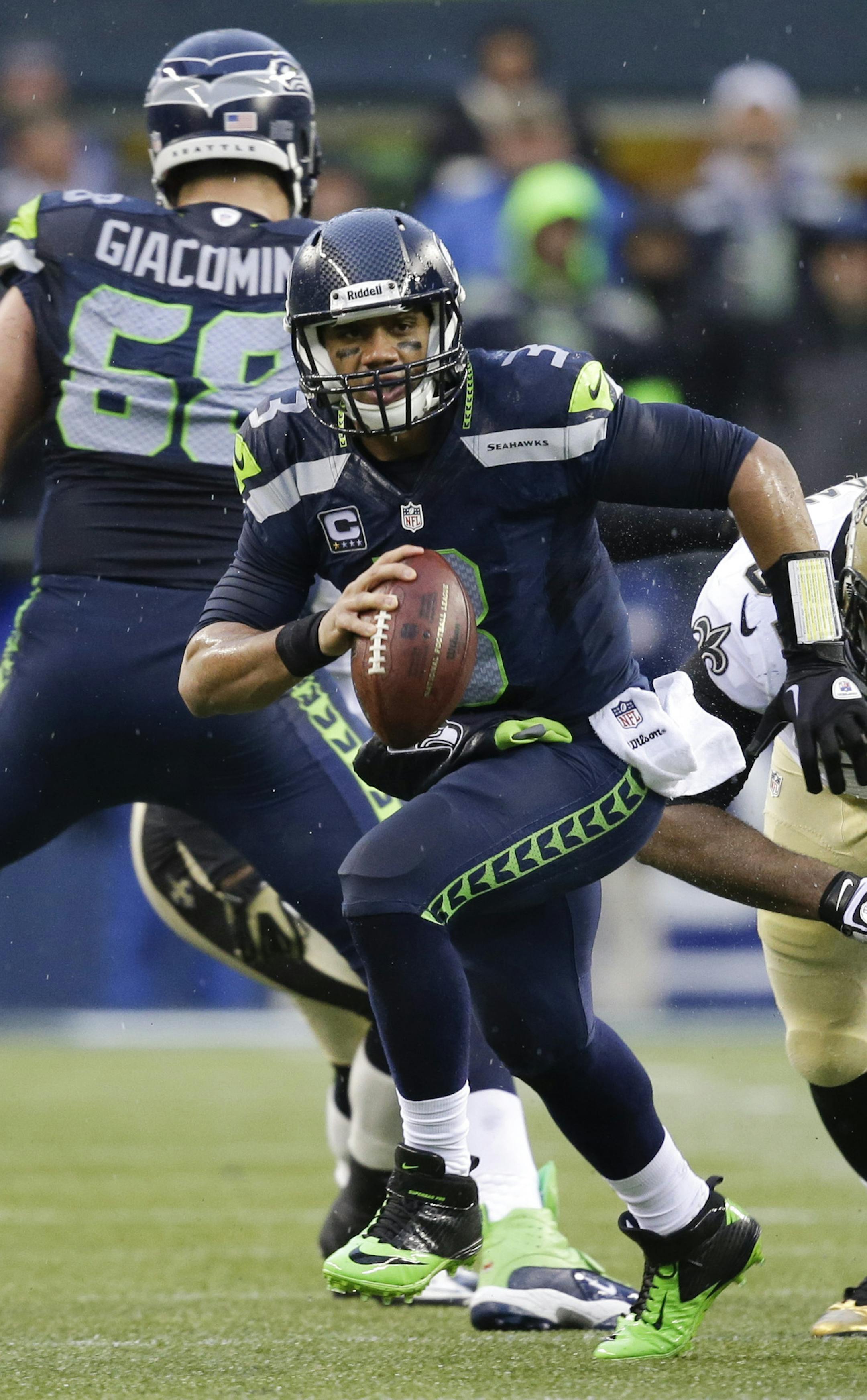 Seattle Seahawks quarterback Russell Wilson (3) scrambles in front of New Orleans Saints defensive end Cameron Jordan (94) during the second quarter of an NFC divisional playoff NFL football game in Seattle, Saturday, Jan. 11, 2014. (AP Photo/Elaine Thompson) ORG XMIT: NYOTK