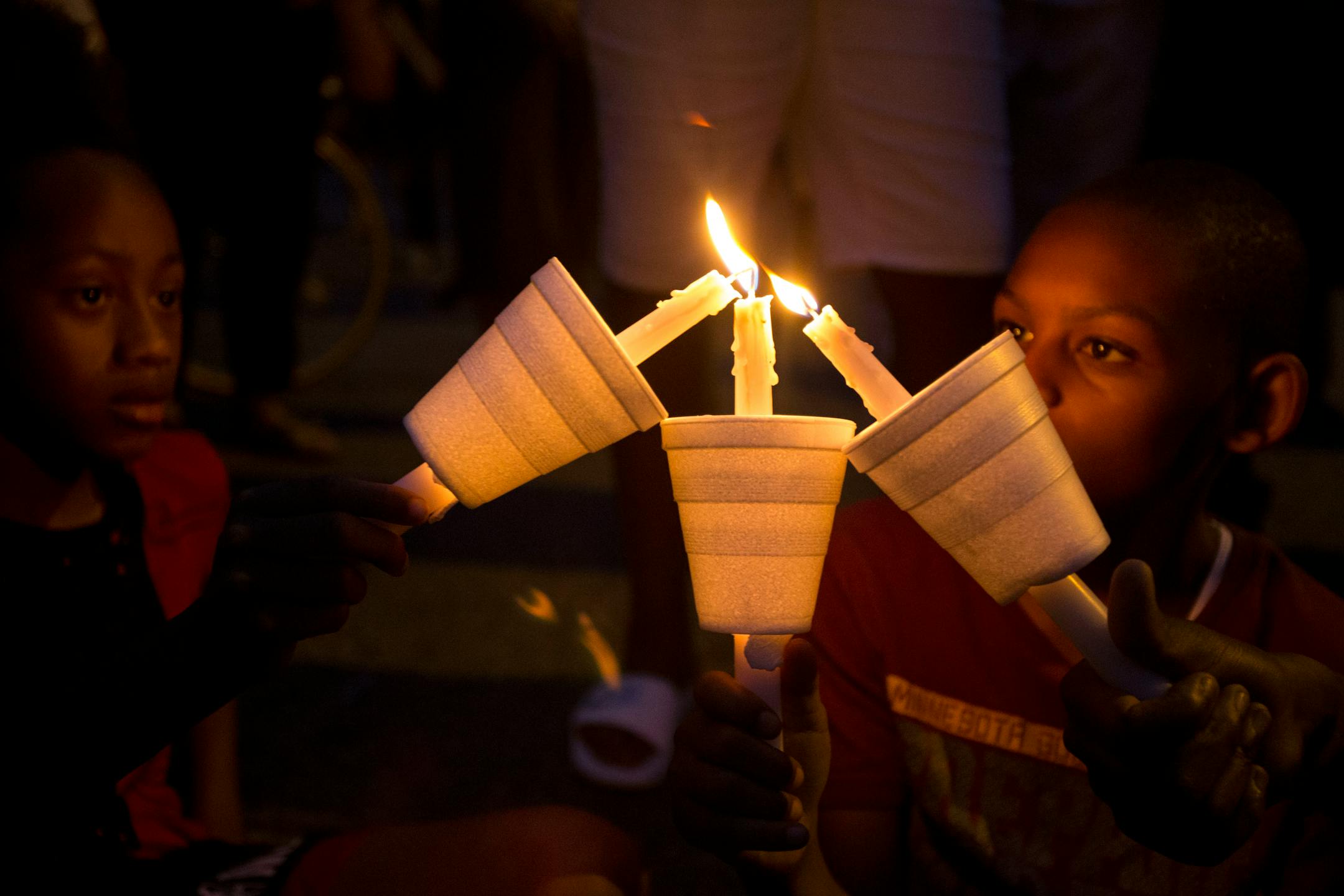Christian Young, Damarion Sims and Emahnie Griffin put their candles together to help one another keep their candle lit during the vigil Sunday night . ] ALEX KORMANN � alex.kormann@startribune.com Dozens of local community members, family of Thurman Belvins and activists gathered at the corner of 48th street and Camden Ave on Sunday evening for a candle lit vigil to remember the life of Belvins who died Saturday. Belvins was shot by police starting on that same corner Saturday afternoon. Commun