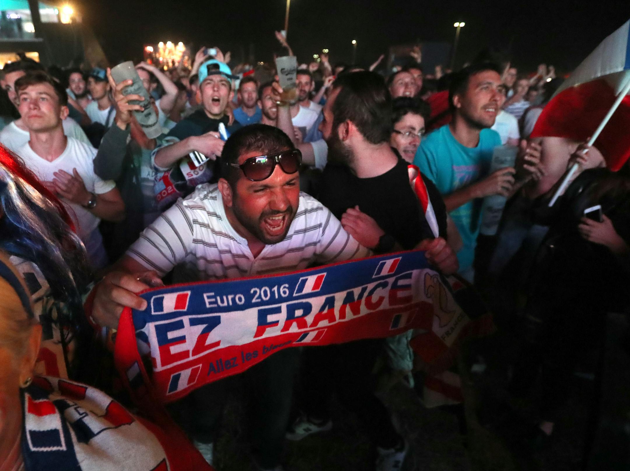 Soccer fans react as they watch on giant screens the Euro 2016 Group A soccer match between France and Romania in the fan zone in Marseille, southern France, as part of the Euro 2016 Soccer Championship, Friday, June 10, 2016. (AP Photo/Claude Paris)