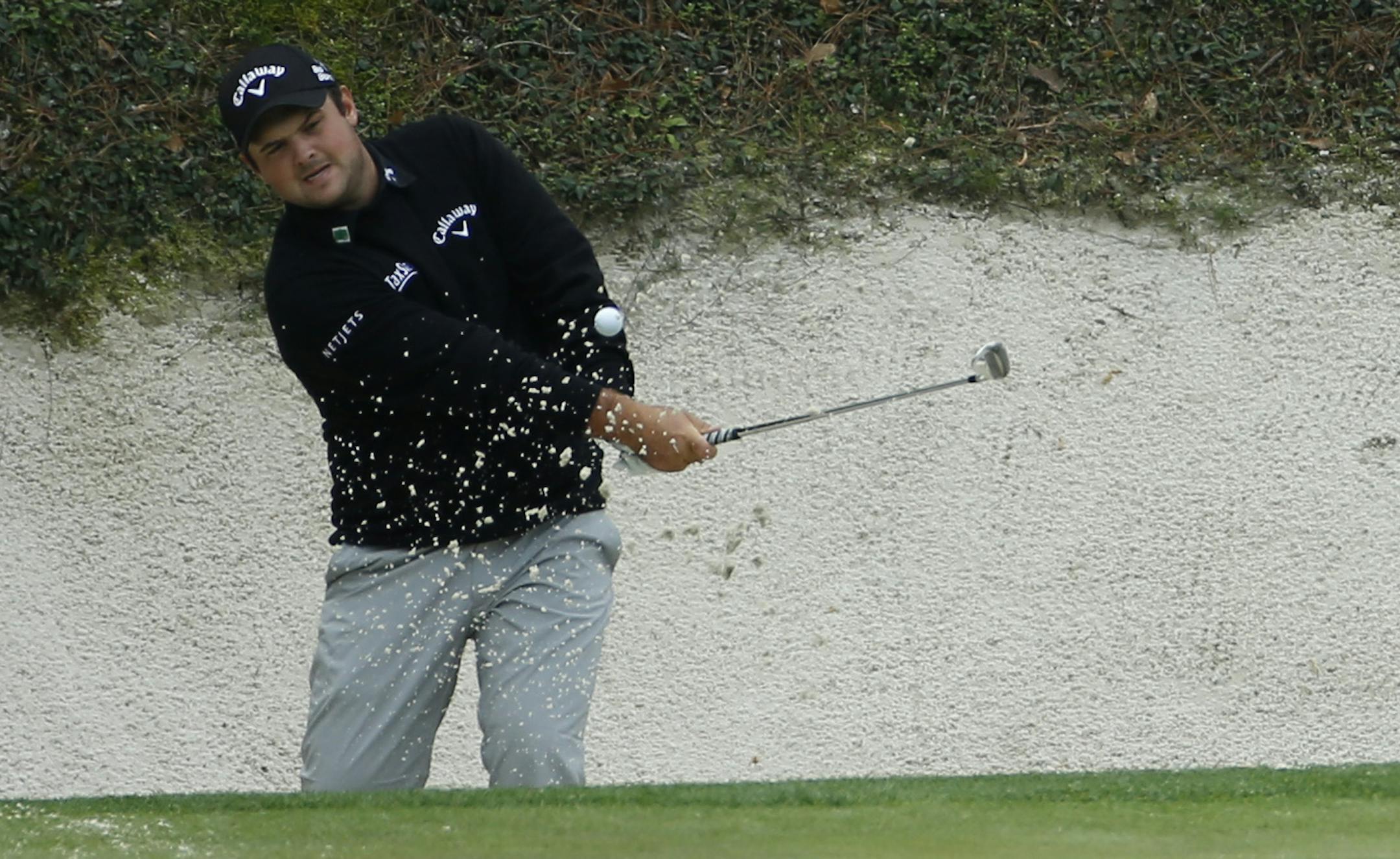 Patrick Reed chips out of a bunker on the 12th hole during a practice round for the Masters golf tournament Tuesday, April 8, 2014, in Augusta, Ga. (AP Photo/Matt Slocum)