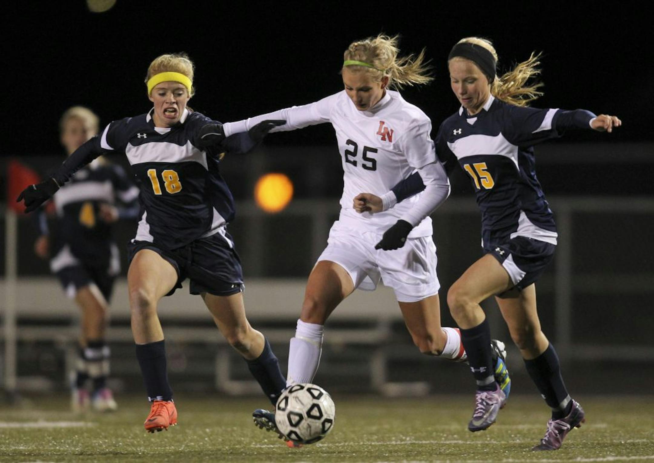Lakeville North's Alexa Trakalo dribbled the ball while pressured by Prior Lake's Macy Violett, left, and Jade Weller.