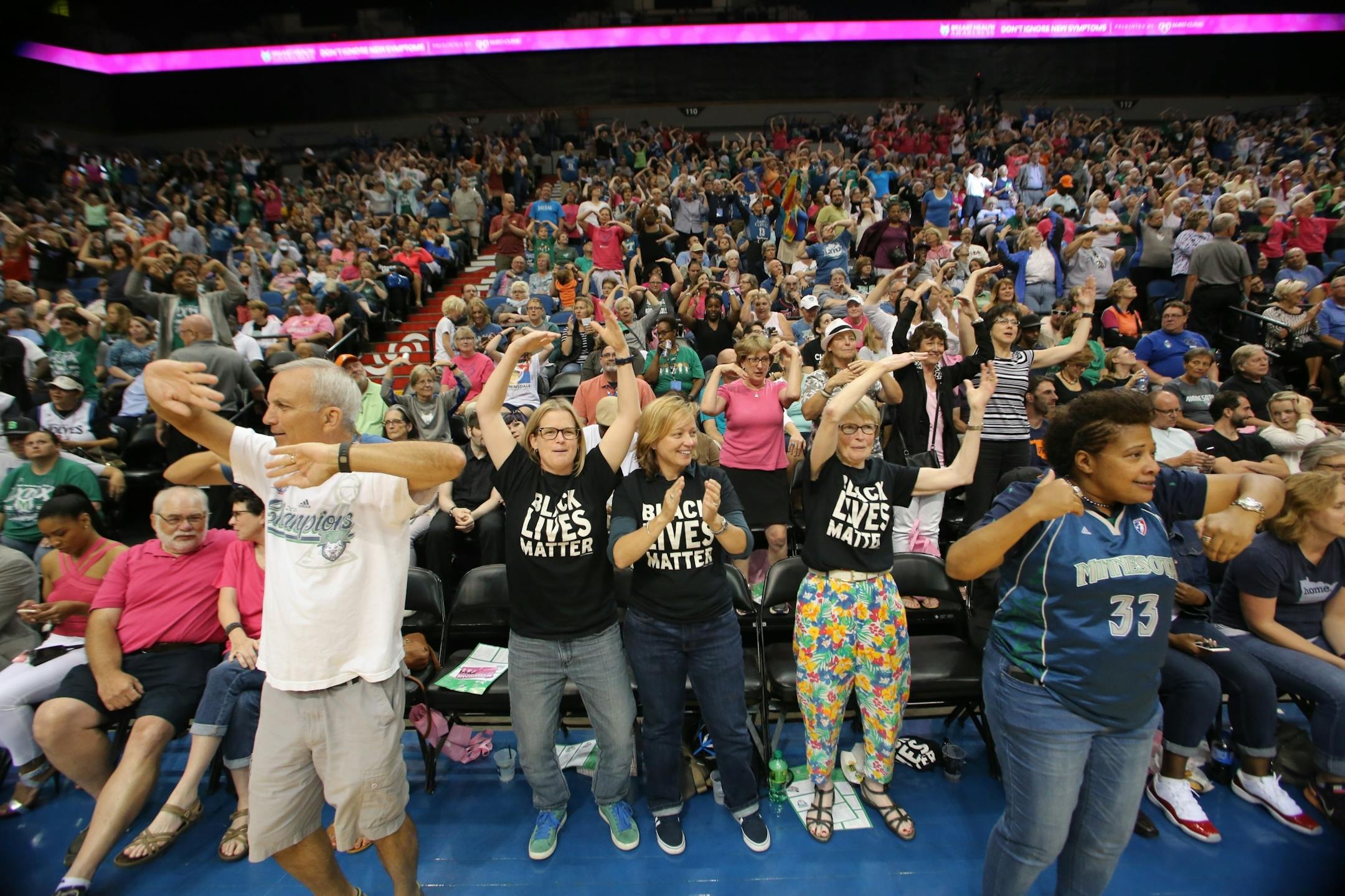 Sporting Black Lives Matter shirts, from left, Vija Brookshire, Julieann Swanson, and Jacqueline Teisberg danced with the crowd to the YMCA song during a timeout at Friday's Lynx game.