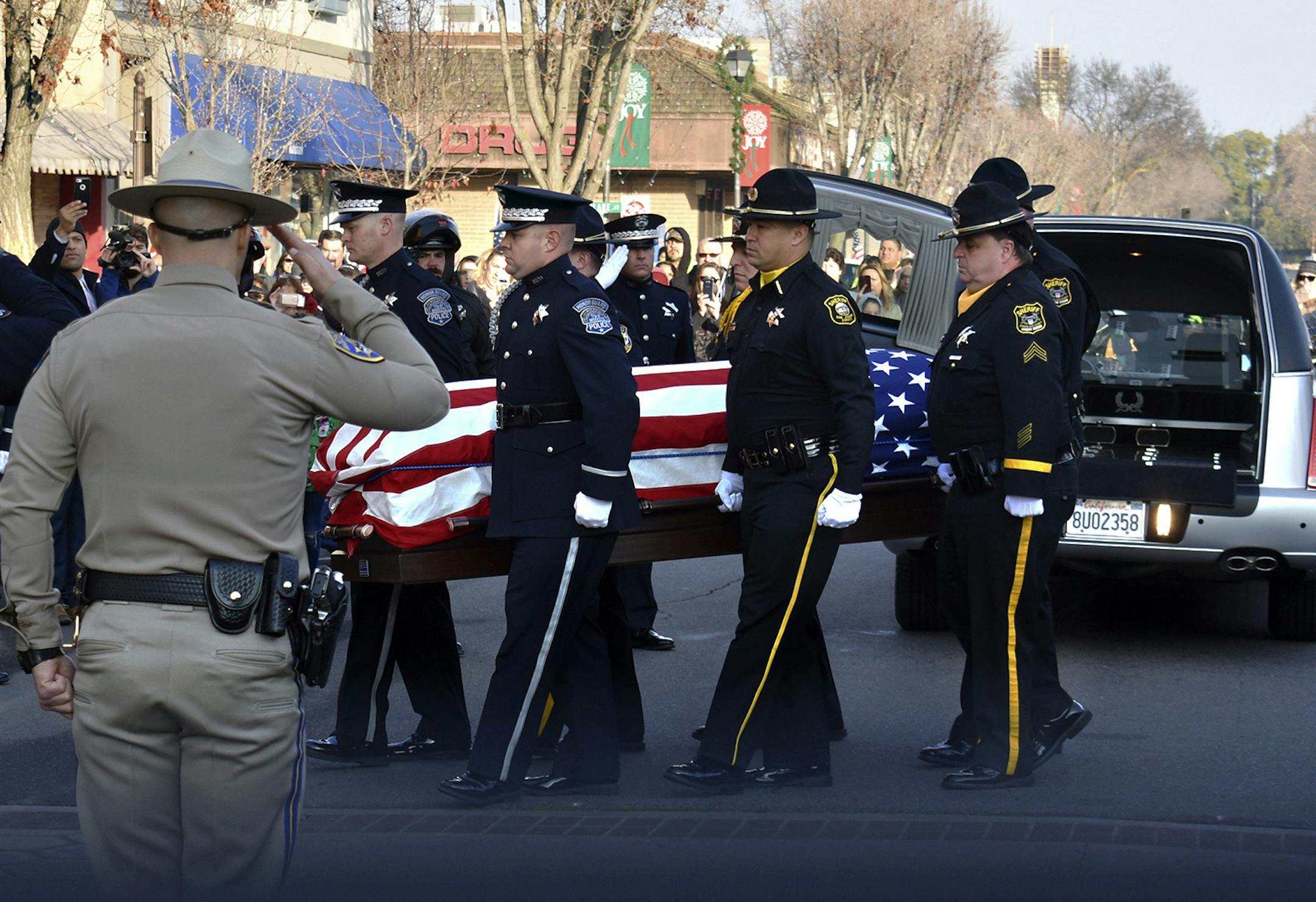 Law enforcement officials carry the casket of Newman Police Cpl. Ronil Singh into the Westside Theatre for a public viewing in Newman, Calif., Friday, Jan. 4, 2019.Prosecutors on Wednesday, Jan. 2, charged Gustavo Perez Arriaga in Singh's killing. Perez Arriaga, who was in the country illegally, was arrested after a dayslong manhunt as he prepared to flee to Mexico, authorities said. (Deke Farrow/The Modesto Bee via AP)
