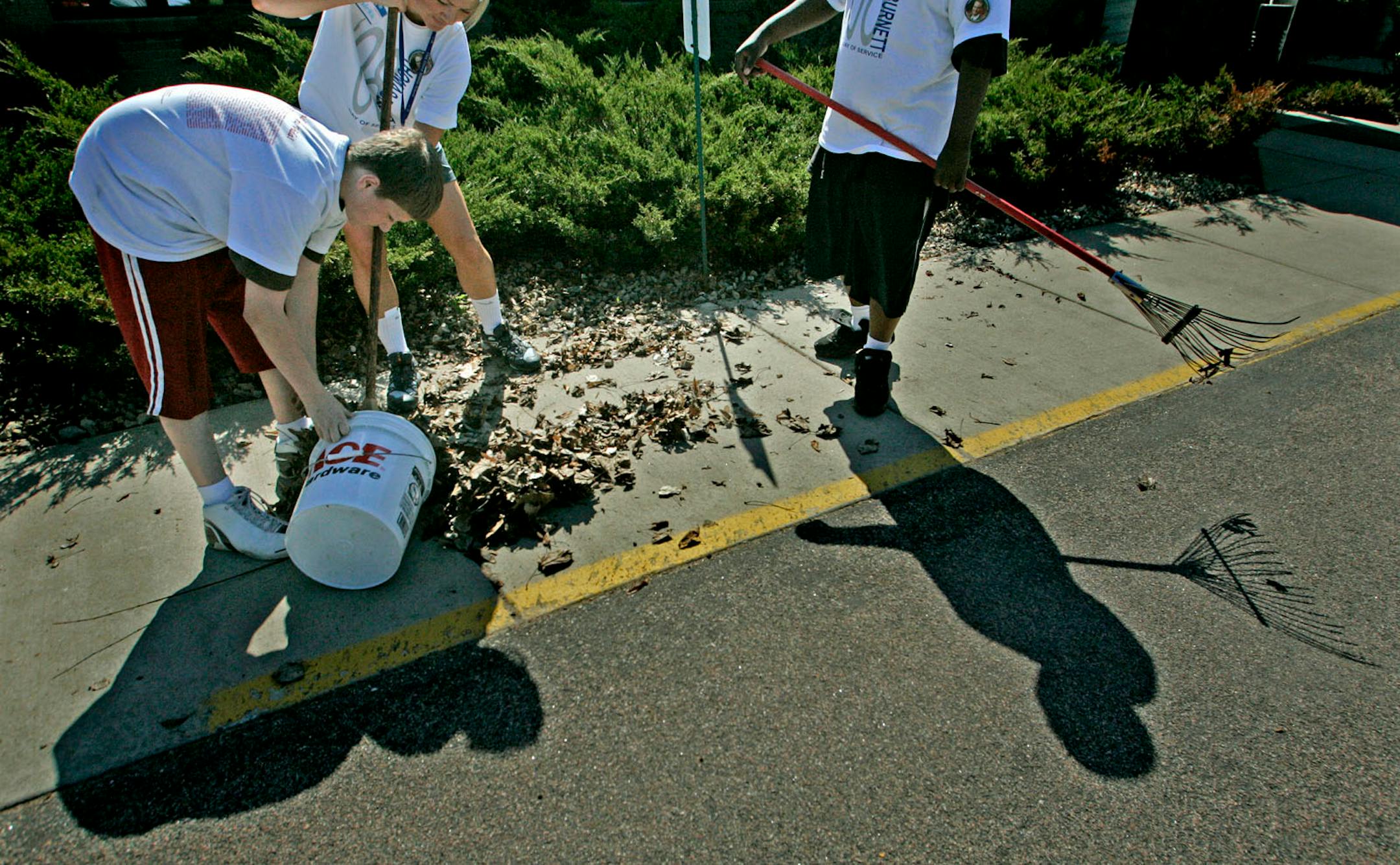 May 16, 2008 - Inver Grove Heights, MN - Bloomington Oak Grove Middle School students Eric McMahon, 14, teacher Katie Kodelka, and Dayton Dottny-Murphy, 14, raked the leaves outside the Good Samaritan Society House. Students and teachers participated in community work to commemorate Bloomington Jefferson High School graduate Tom Burnett with a Memorial Day of Service. Burnett was a victim in the United Flight 93 on September 11, 2001.