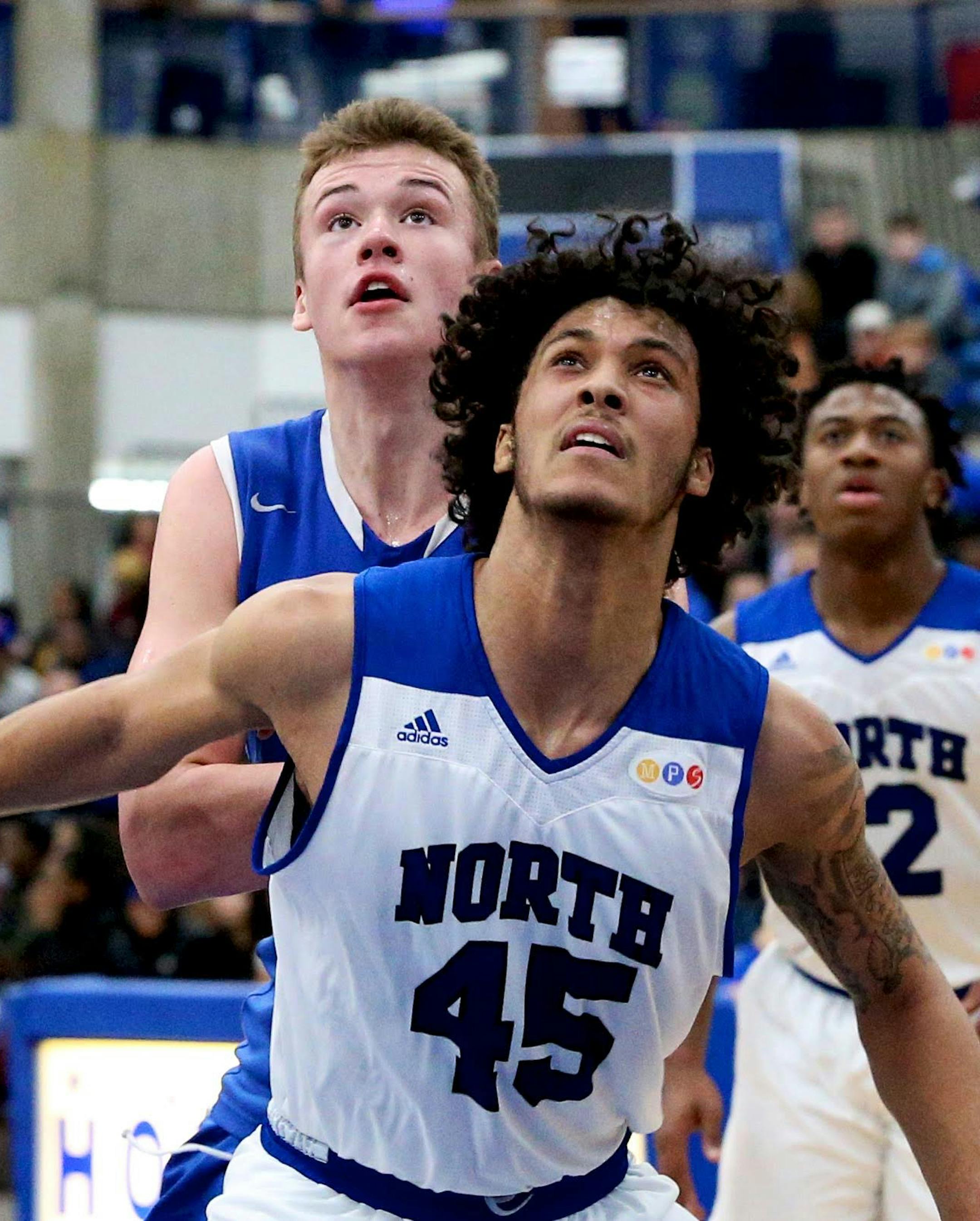 Hopkins senior Simon Wright and Minneapolis North senior Isaac Johnson battle for a rebound in action at Hopkins Lindberg Center. Photo by Brian W Nelson, SportsEngine